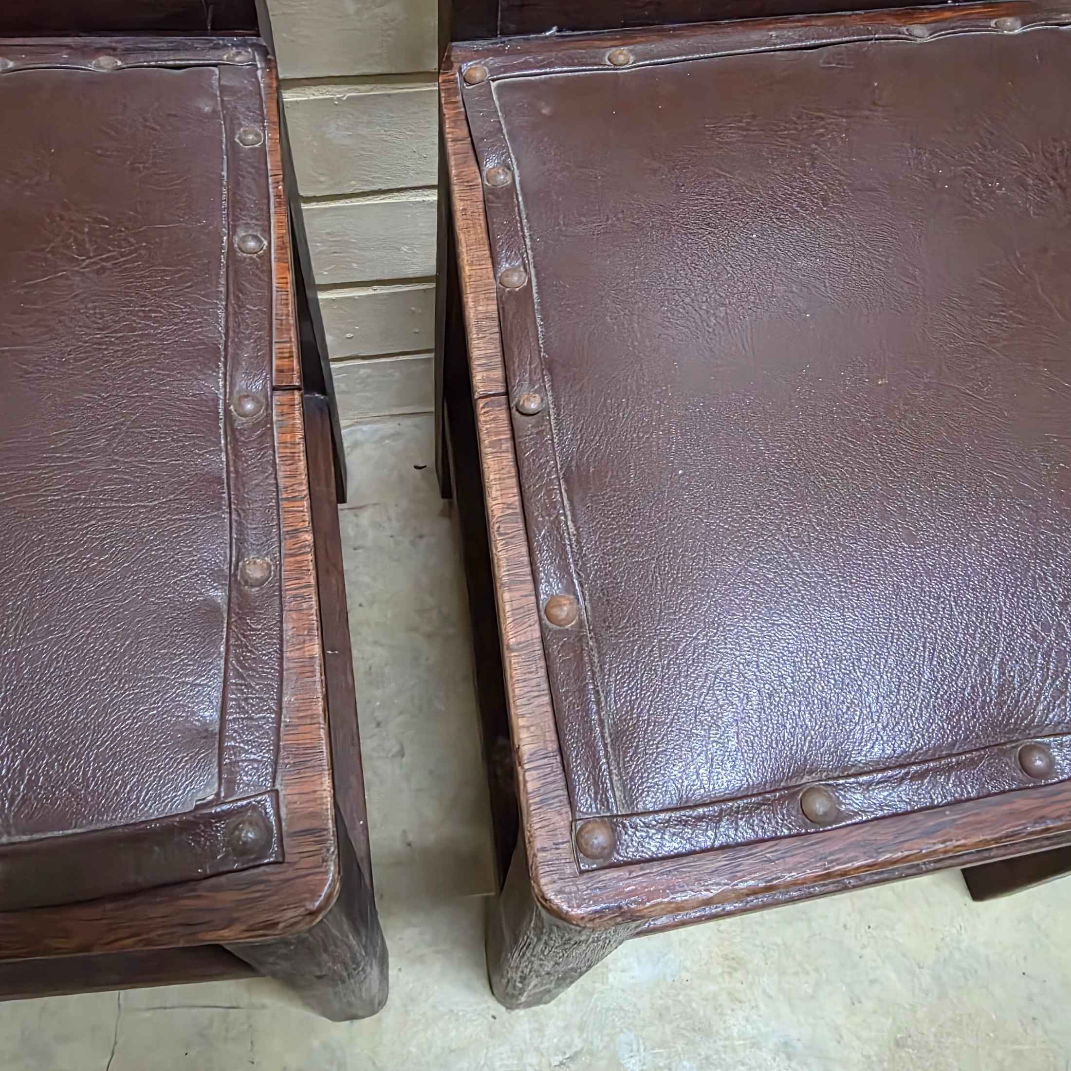 A set of four vintage dark wood dining chairs, featuring a simple, robust design and dark brown studded faux leather seats. - View 8