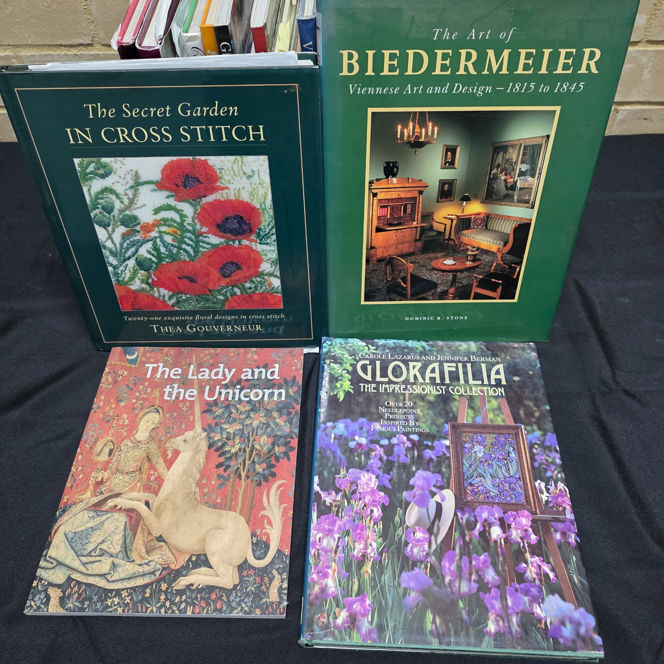 A collection of approximately 18 reference books focusing on needlecrafts and historical design, including titles on cross-stitch, needlepoint, tapestry, and Biedermeier art. - View 2
