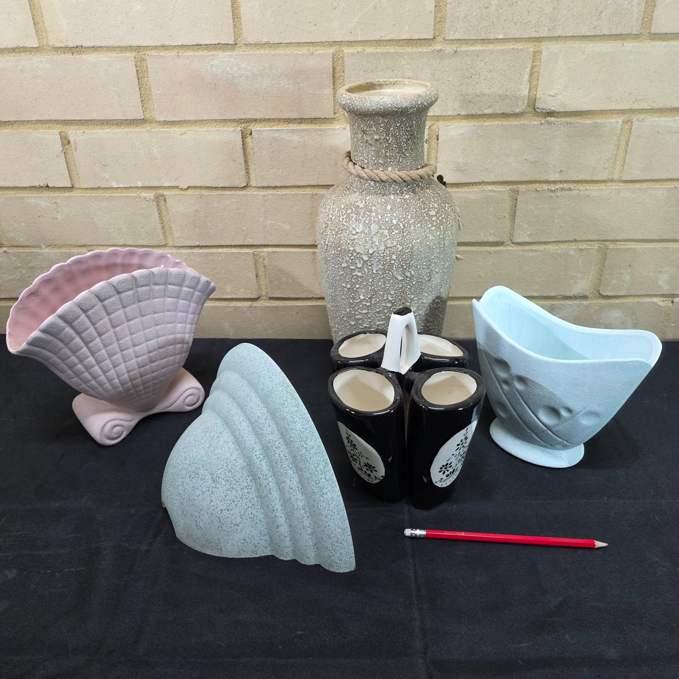 A collection of vintage Australian ceramic sundries, including a textured Micasa vase with rope, a pink Raynham shell-shaped vase, a light blue Surrey vase, a black and white condiment holder, and a light green shell-like decorative piece. - View 2