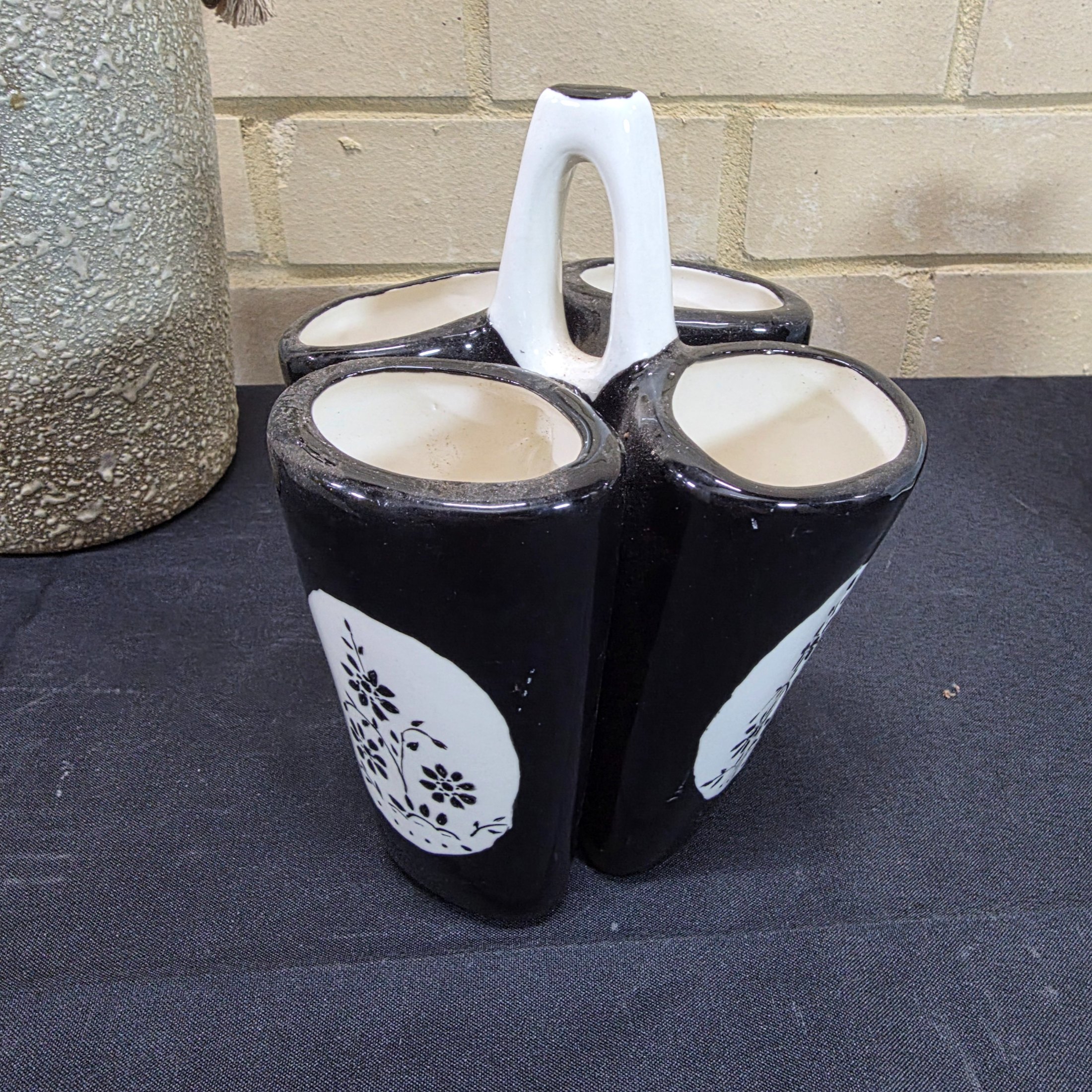 A collection of vintage Australian ceramic sundries, including a textured Micasa vase with rope, a pink Raynham shell-shaped vase, a light blue Surrey vase, a black and white condiment holder, and a light green shell-like decorative piece. - View 6
