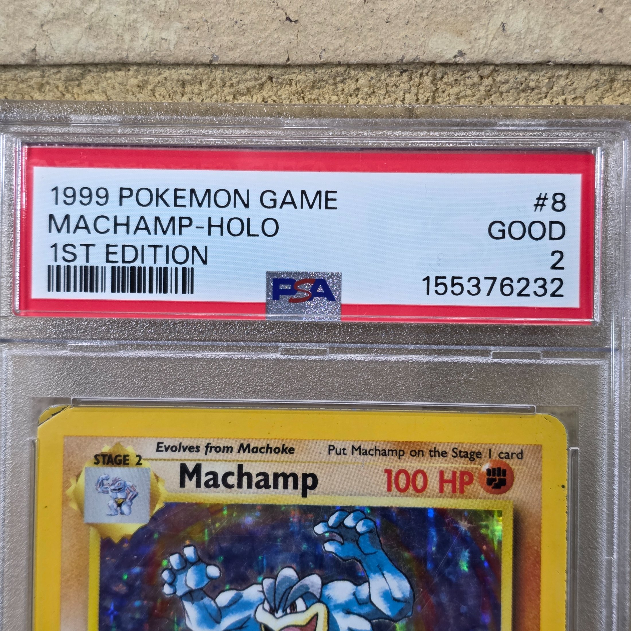 A 1999 Pokémon Game Machamp-Holo 1st Edition trading card, professionally graded PSA GOOD 2, displayed in a protective slab. - View 4