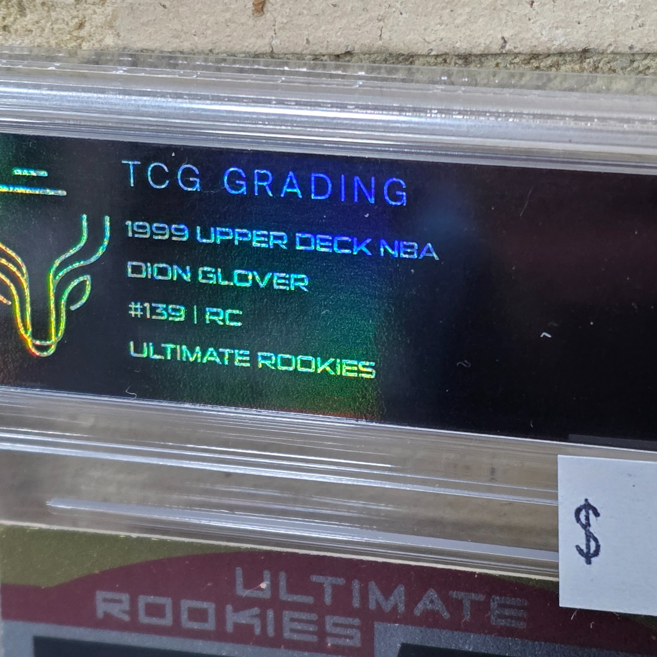 A 1999 Upper Deck NBA basketball rookie card of Dion Glover, graded 7 NM by TCG Grading, encapsulated in a protective slab. - View 2