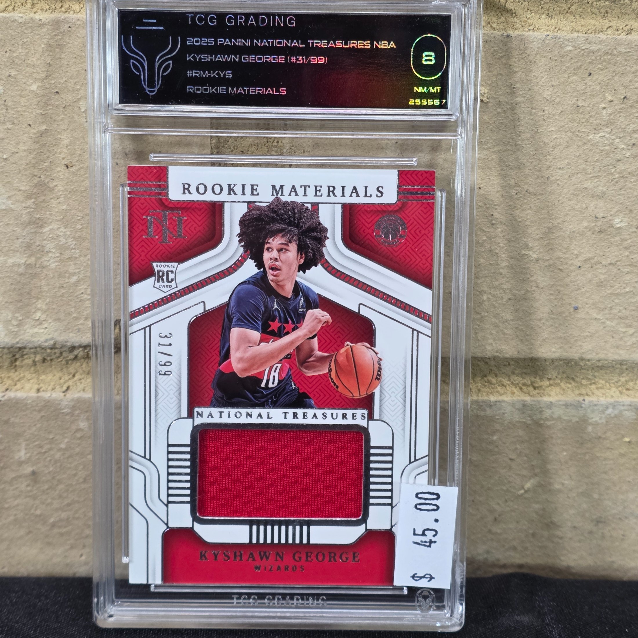 A 2025 Panini National Treasures NBA Kyshawn George Rookie Materials trading card, graded 8 NM/MT by TCG Grading, featuring a jersey patch.