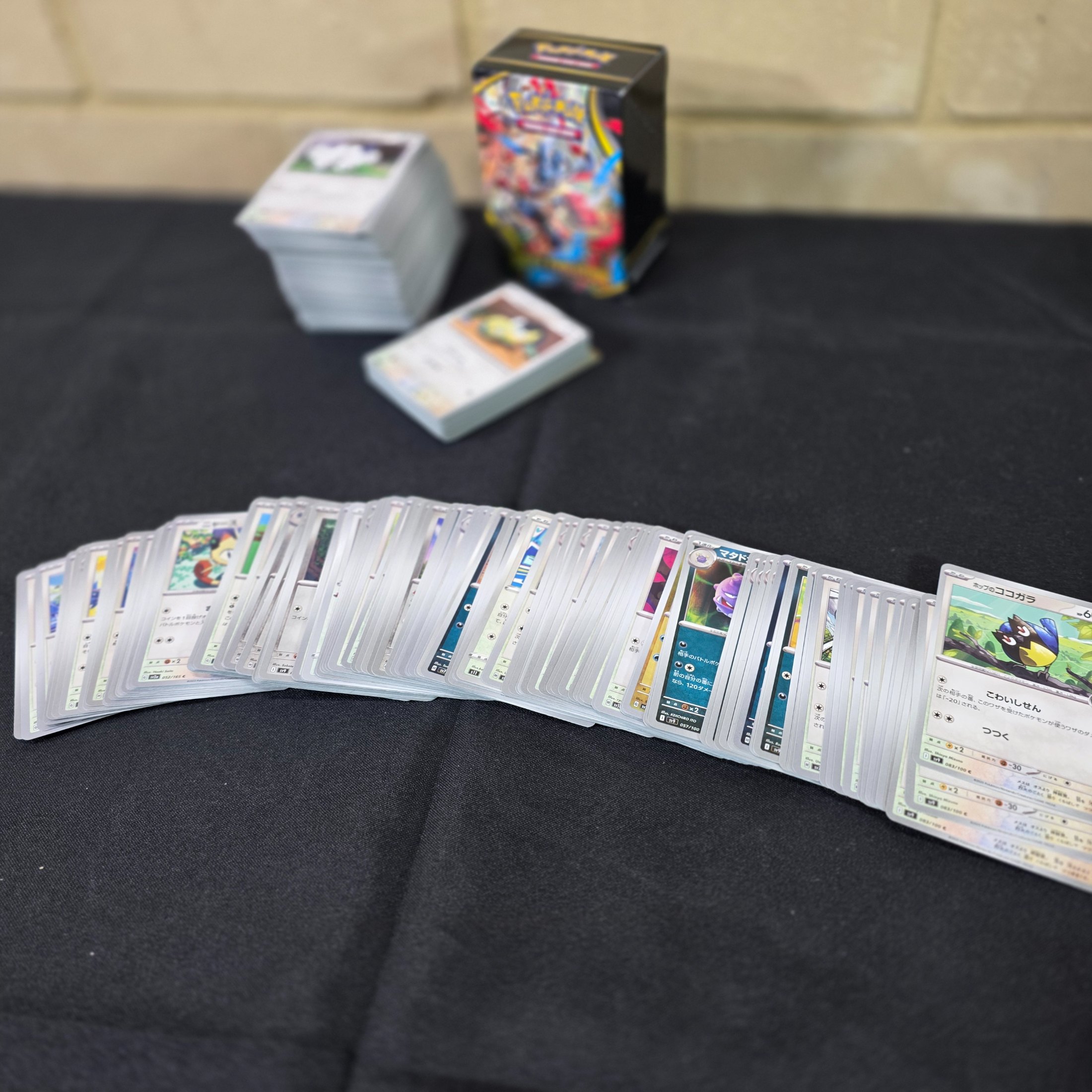 A collection of Japanese Pokémon Trading Card Game cards, including a "Mega Evolution" themed box and multiple stacks of cards. - View 4