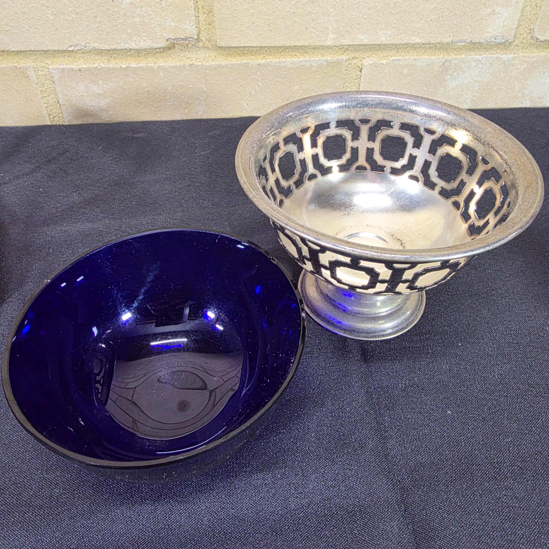 A diverse lot of antique and vintage items, including a rusty cast iron flat iron, a silver-plated bowl with a cobalt blue glass insert holding decorative painted eggs, and a Chinese crackle-glazed ceramic lidded jar with blue characters. - View 8
