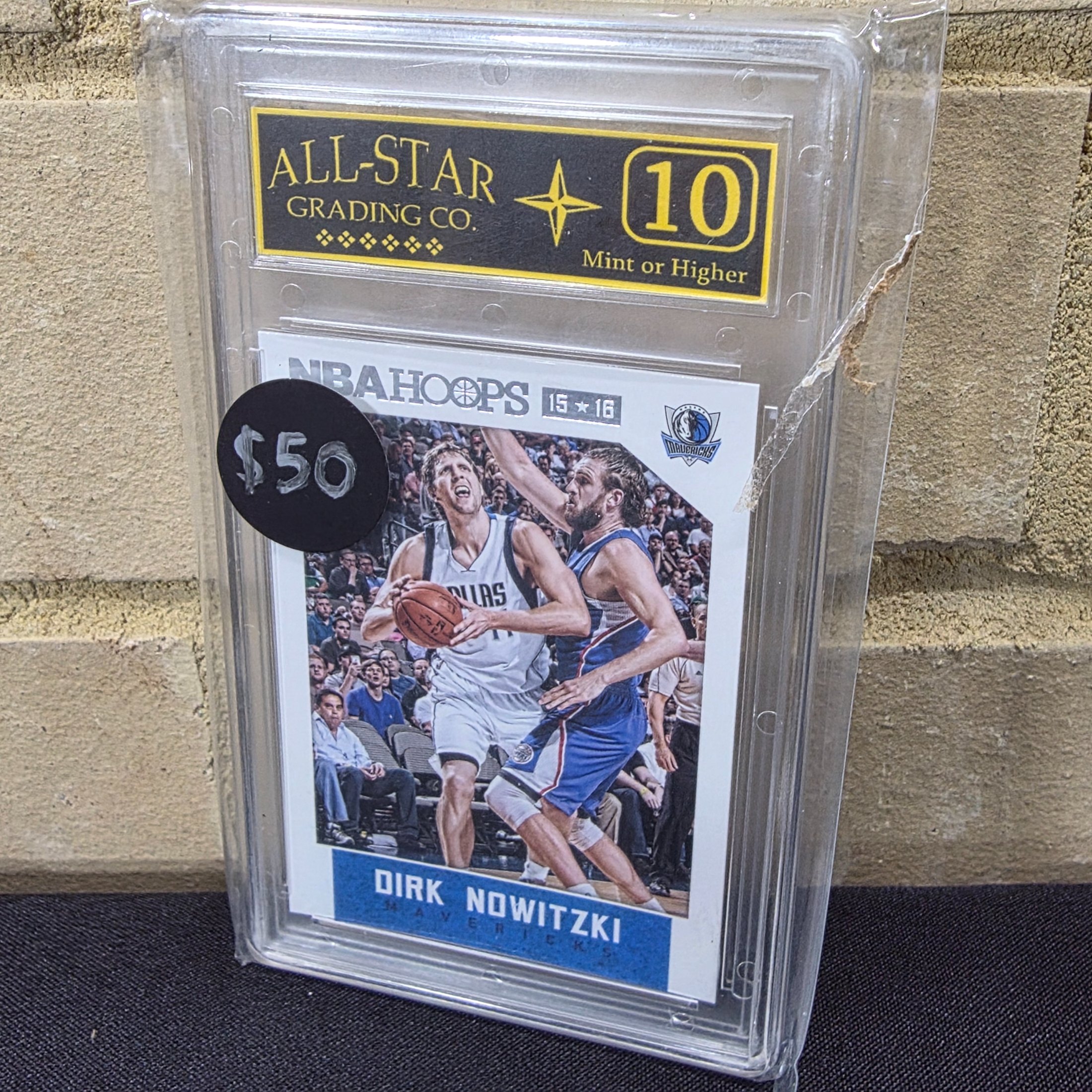 A graded NBA Hoops basketball trading card from the 2015-16 season featuring Dirk Nowitzki, encapsulated and graded 10 Mint or Higher by All-Star Grading Co.
