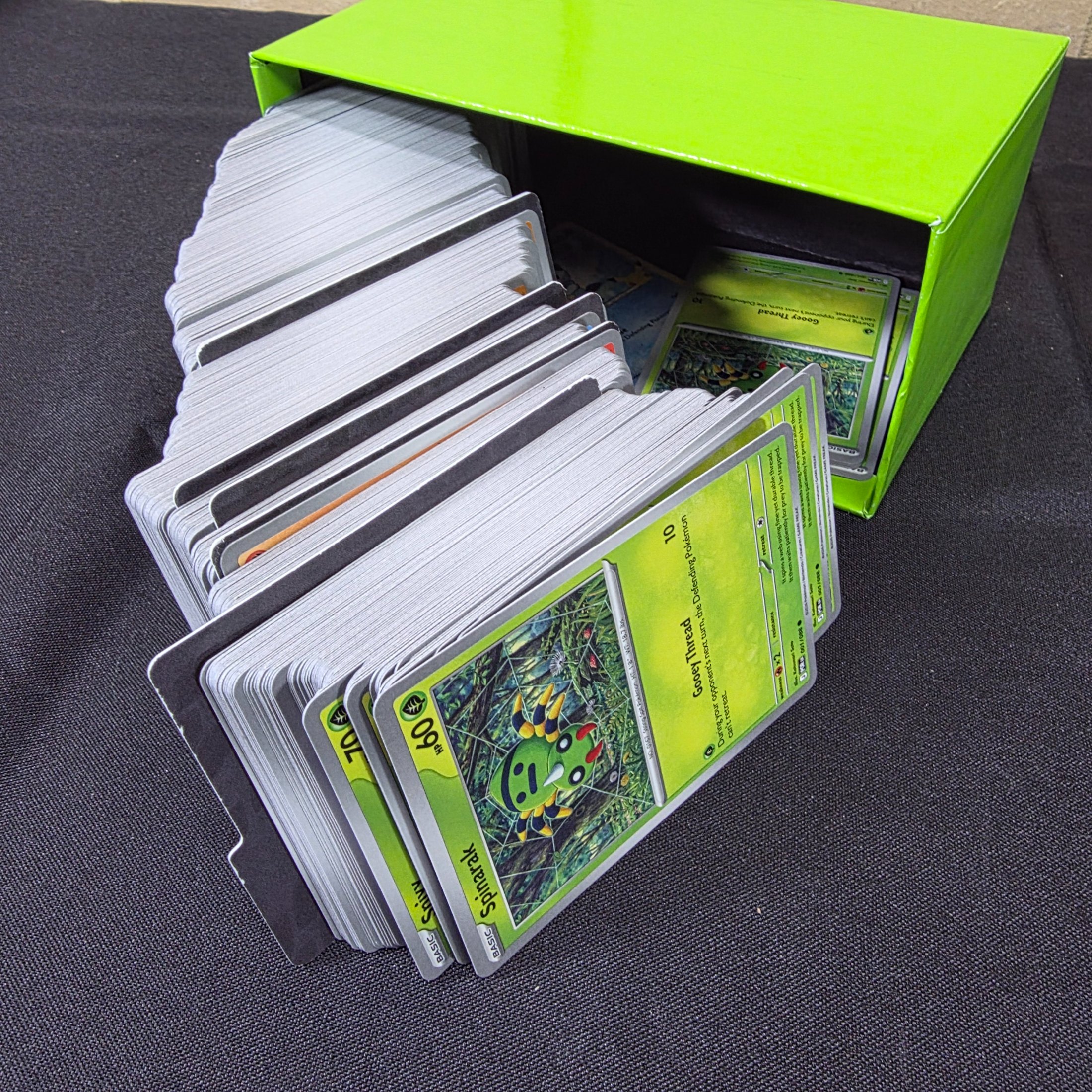 A green and black Pokémon Trading Card Game 'Perfect Order' storage box filled with assorted bulk cards. - View 4