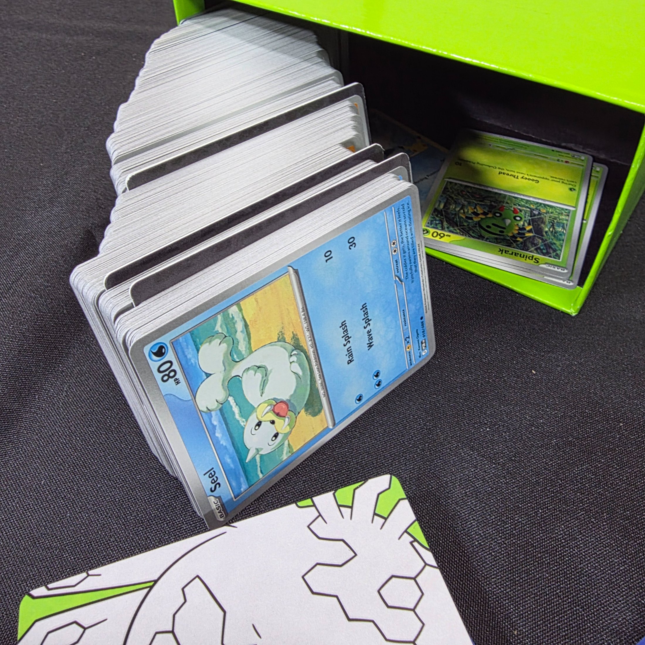 A green and black Pokémon Trading Card Game 'Perfect Order' storage box filled with assorted bulk cards. - View 6