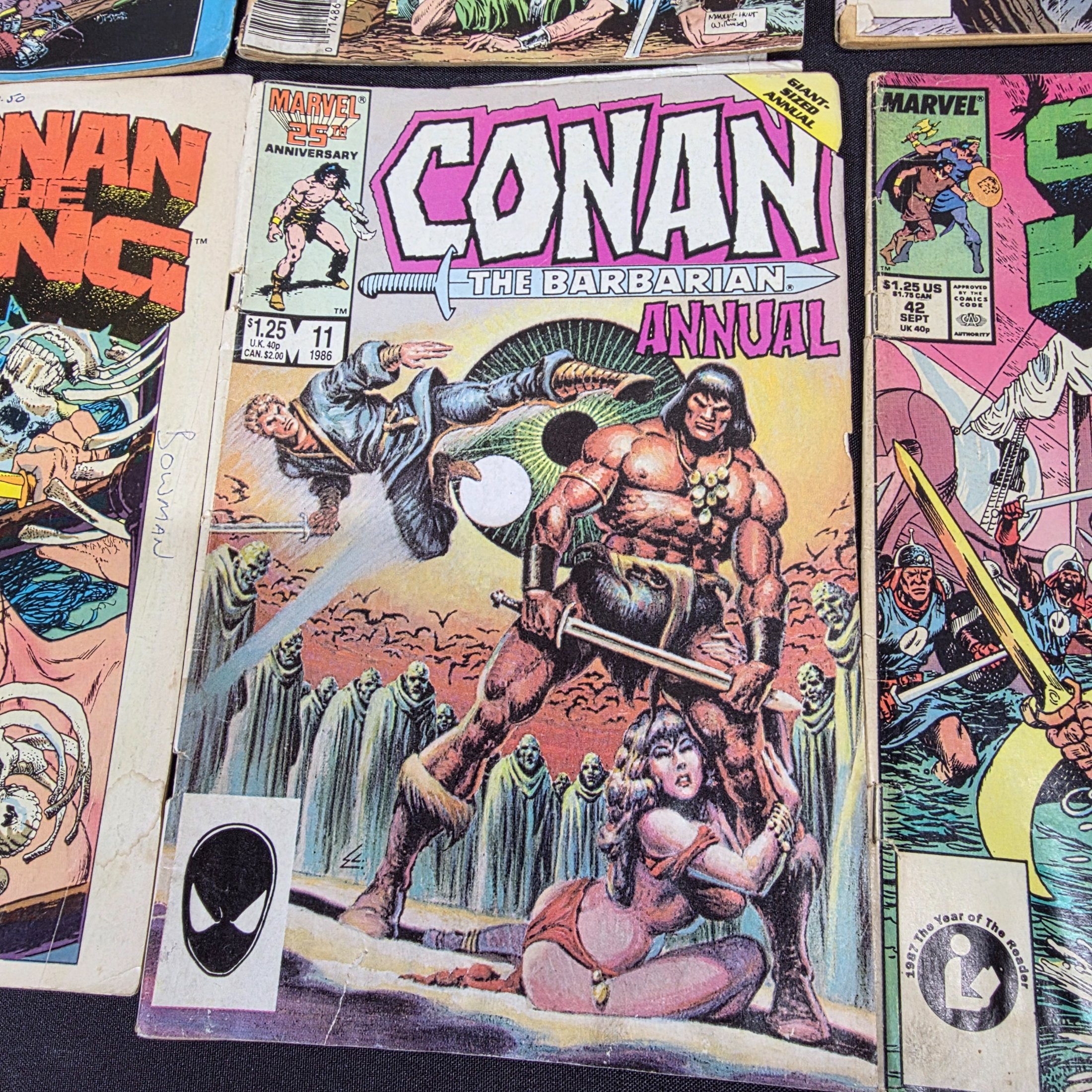 A collection of vintage Marvel 'Conan the King' and 'Conan the Barbarian' comic books from the 1980s, displayed on a black surface against a brick wall. - View 5