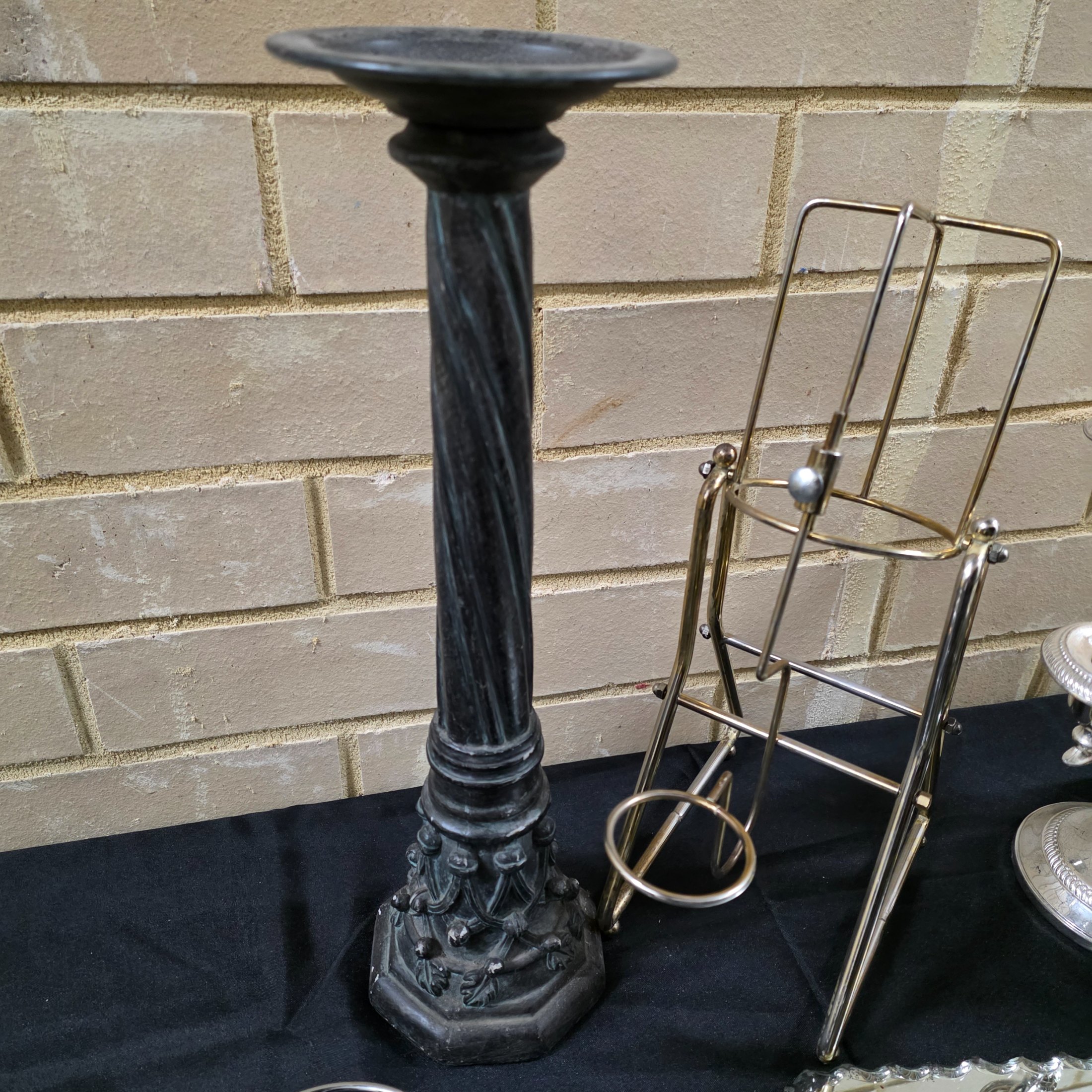 A varied collection of vintage homewares featuring a dark metal candlestick, a silver-plated candelabra, a mirrored tray, and several other decorative and functional pieces. - View 2