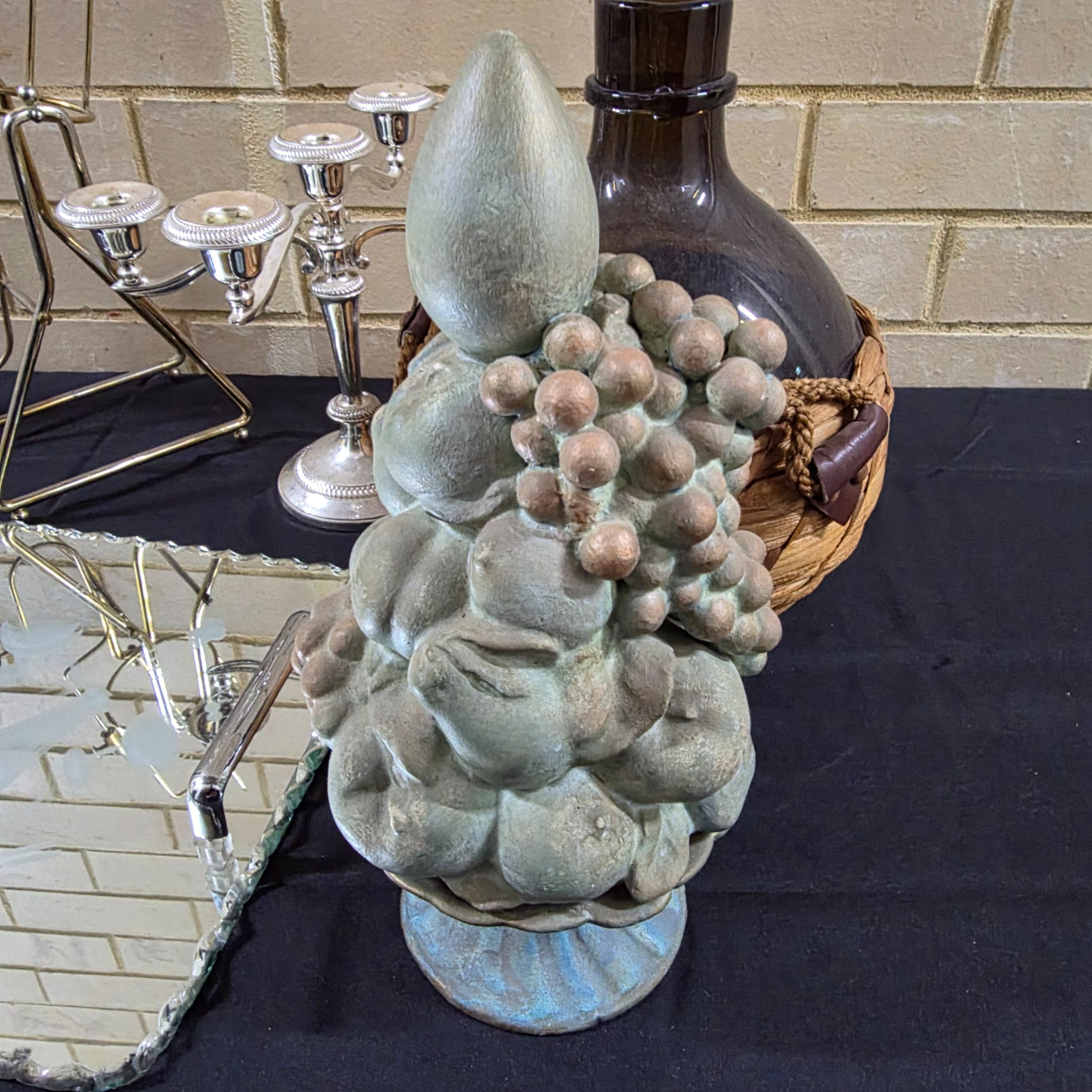 A varied collection of vintage homewares featuring a dark metal candlestick, a silver-plated candelabra, a mirrored tray, and several other decorative and functional pieces. - View 7