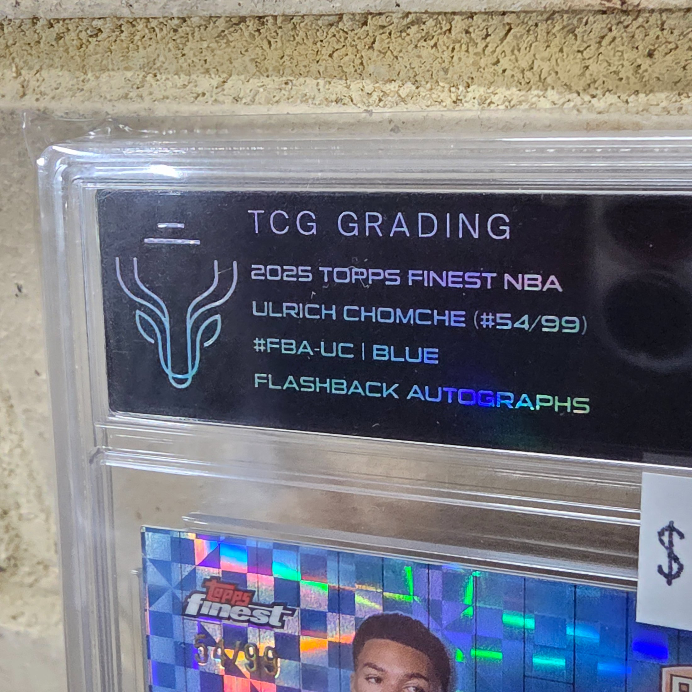 A professionally graded 2025 Topps Finest NBA basketball trading card featuring Ulrich Chomche, numbered 54 of 99, with a Flashback Autograph and a Blue Parallel, encapsulated by TCG Grading with a grade of 8.5 NM/MT-. - View 2