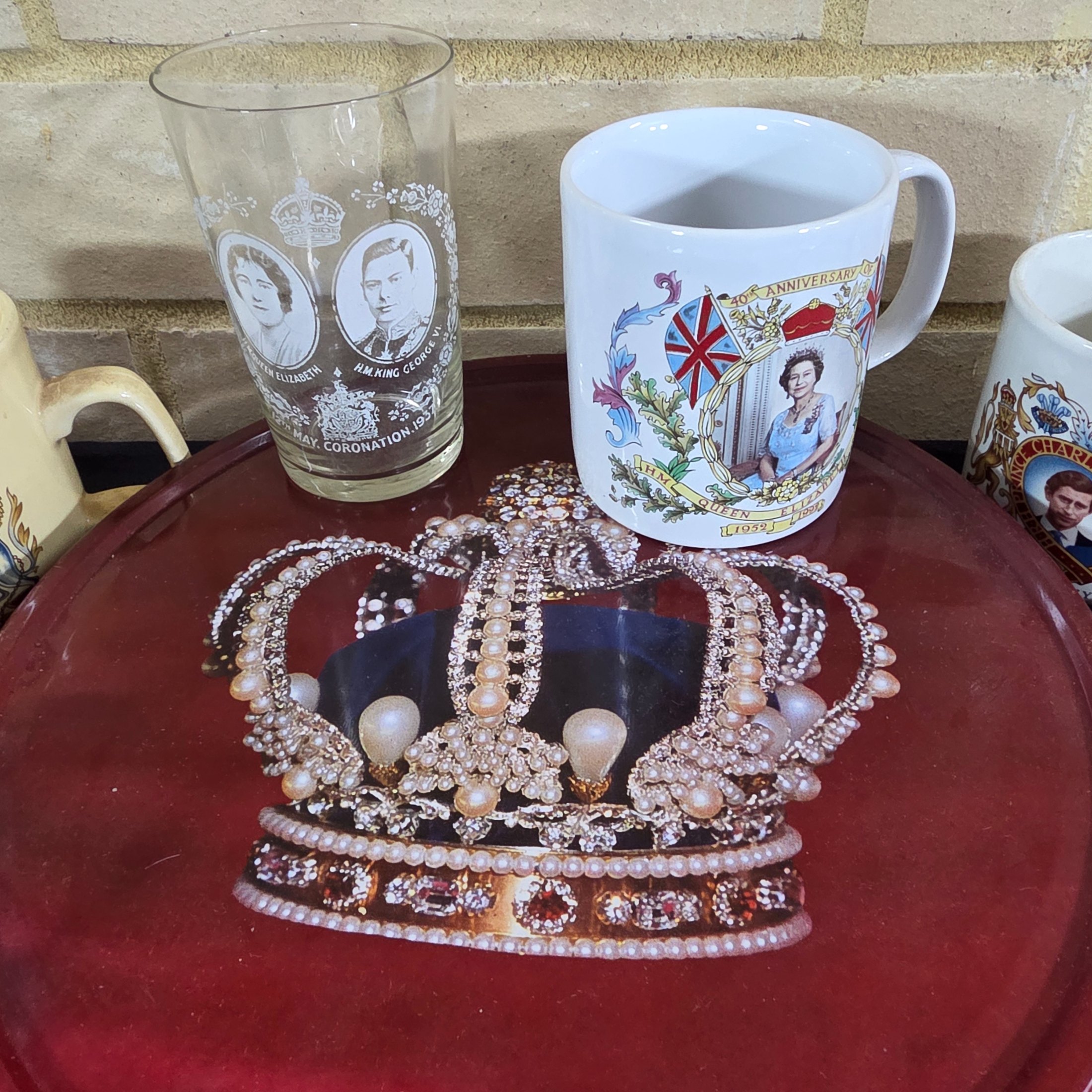 A diverse collection of commemorative ceramics, decorative mugs, and various household sundries from the mid to late 20th century, including royal memorabilia, novelty mugs, a vintage wax jar, and a tea tin. - View 2