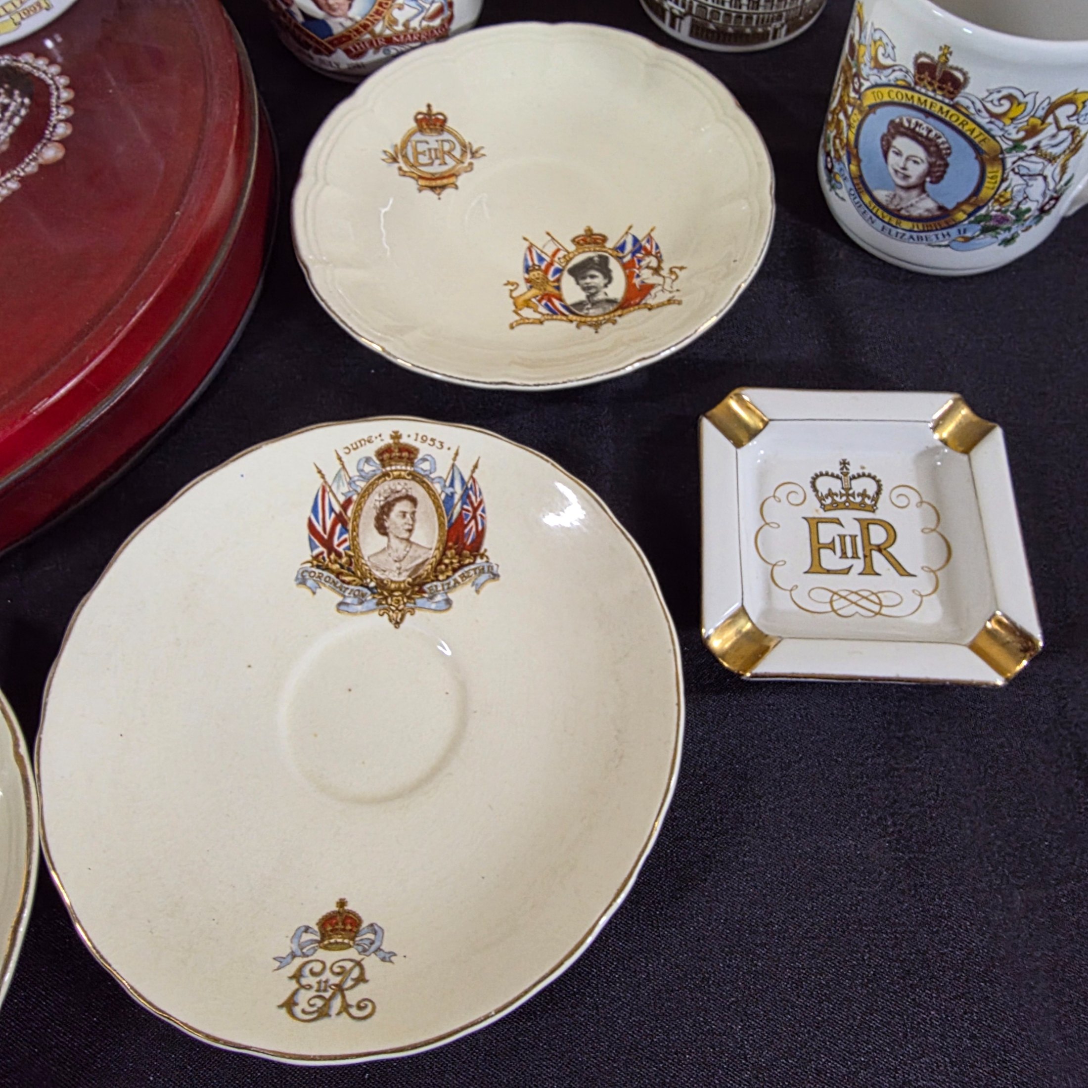 A diverse collection of commemorative ceramics, decorative mugs, and various household sundries from the mid to late 20th century, including royal memorabilia, novelty mugs, a vintage wax jar, and a tea tin. - View 4