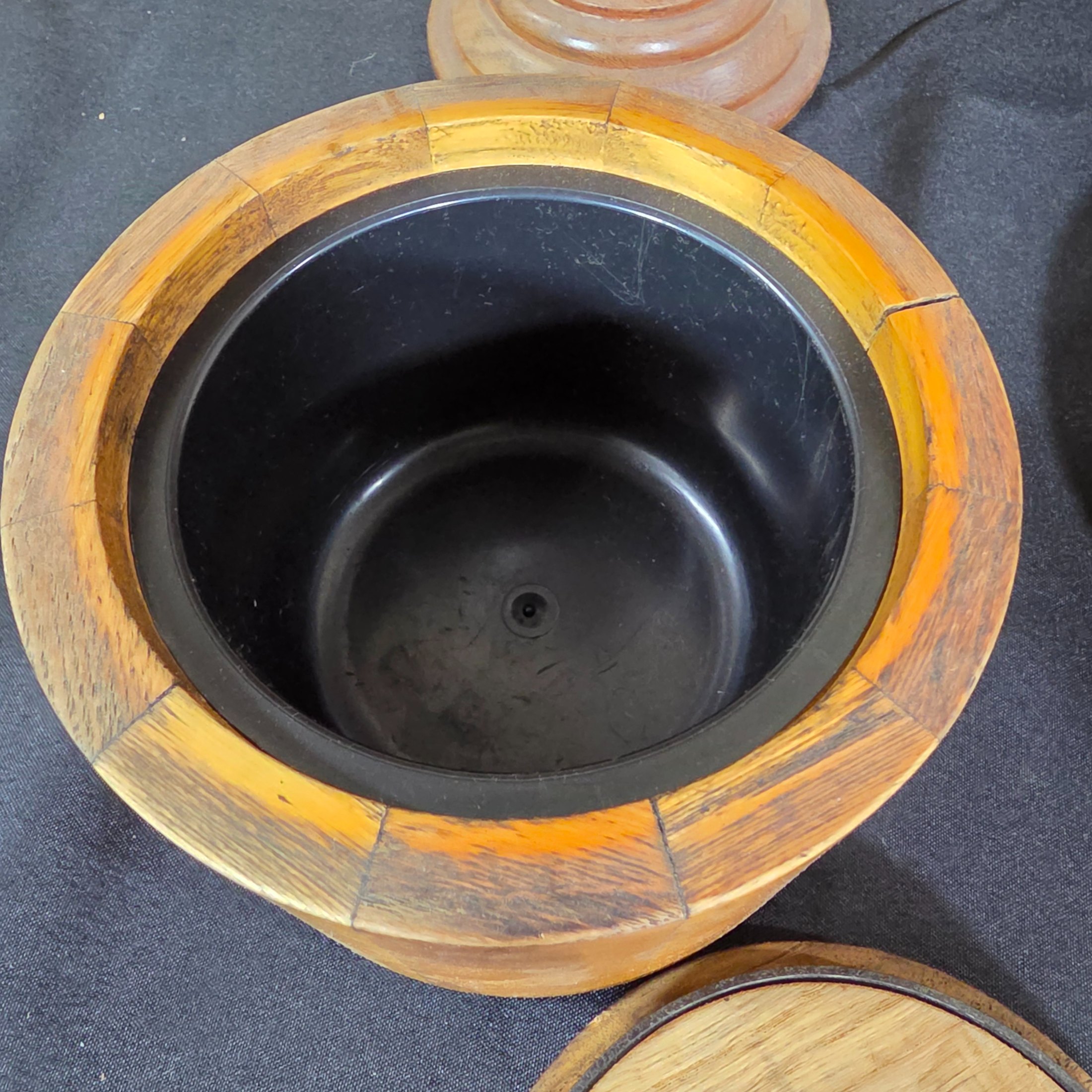 A collection of vintage wooden homewares including a pedestal bowl, lidded container, carved monkey figure, candlestick, wall shelf, and a round trivet. - View 5