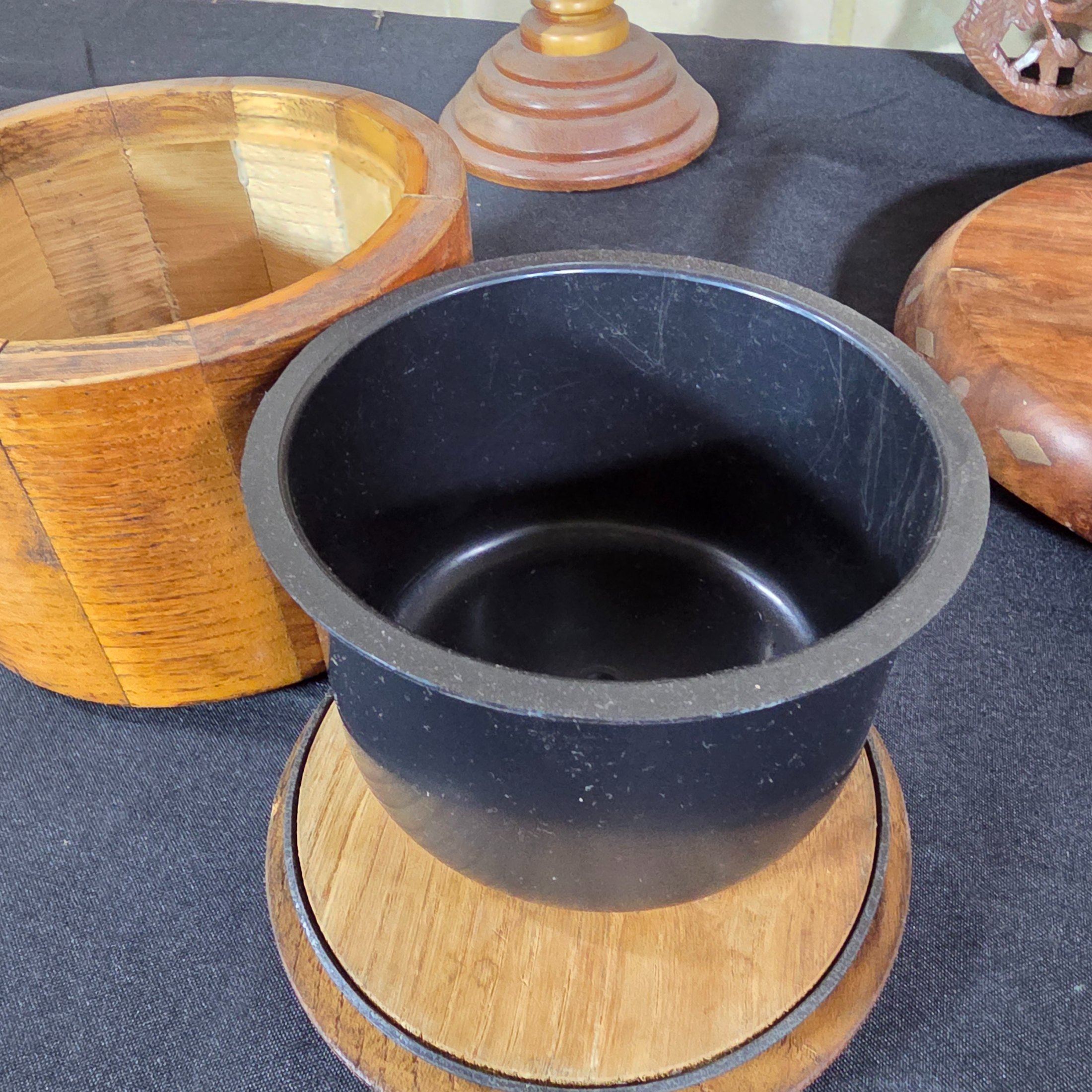 A collection of vintage wooden homewares including a pedestal bowl, lidded container, carved monkey figure, candlestick, wall shelf, and a round trivet. - View 6