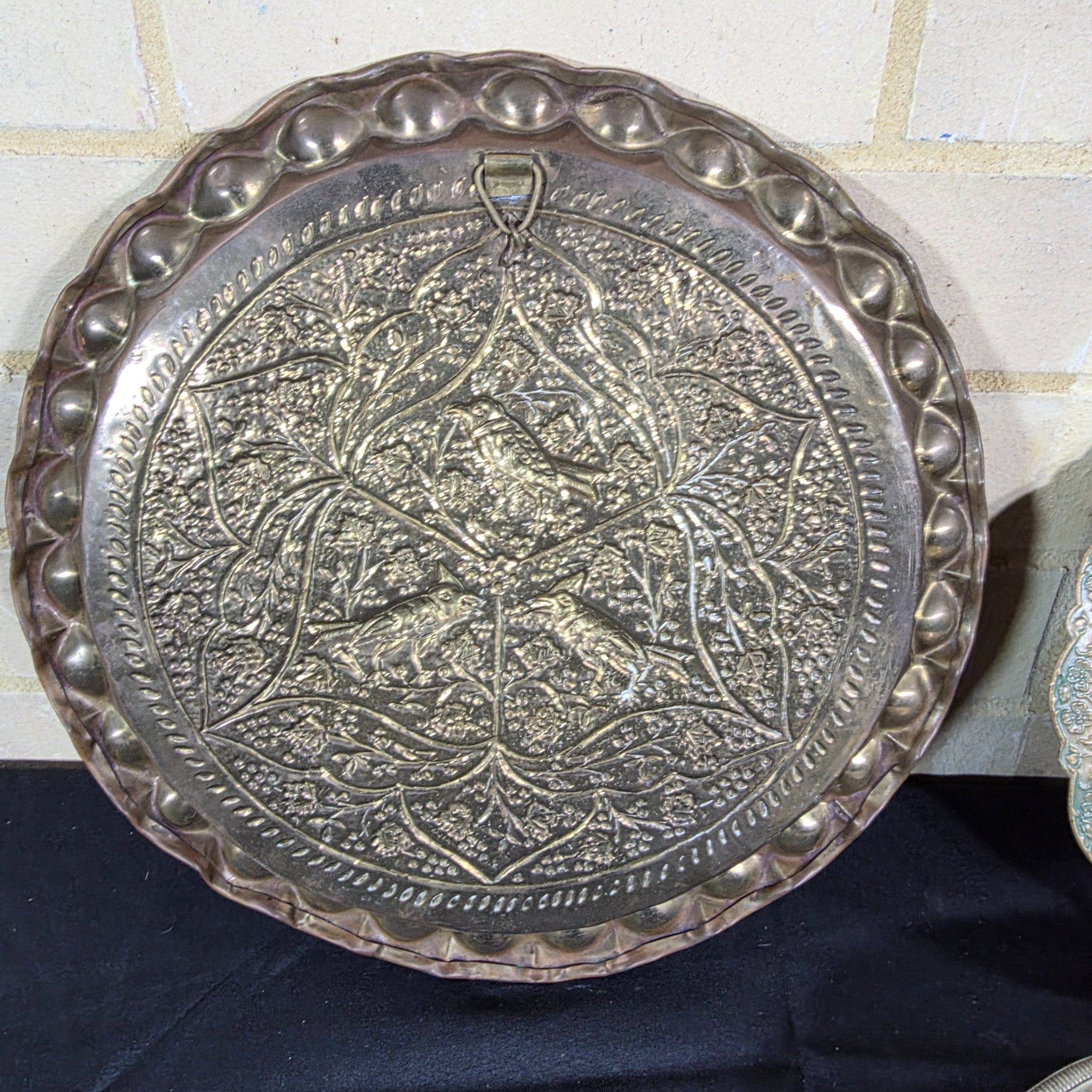 A collection of four assorted decorative metal plates and trays, featuring various embossed and etched designs, suitable for vintage decor. - View 7
