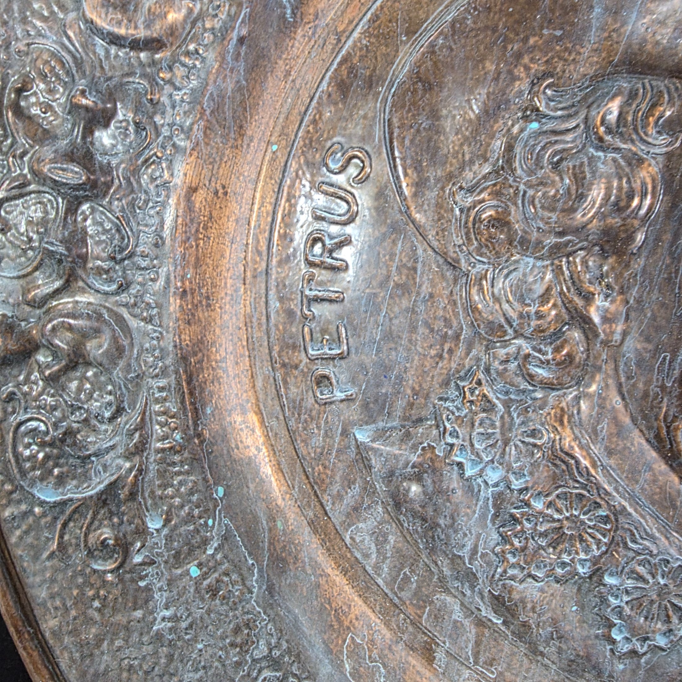 A collection of four vintage embossed metal wall plaques, comprising a large copper-toned plaque featuring a portrait of Peter Paul Rubens, two brass-toned plaques depicting fox hunting and horse-drawn carriage scenes, and a smaller copper-toned plaque with a tavern scene. - View 3