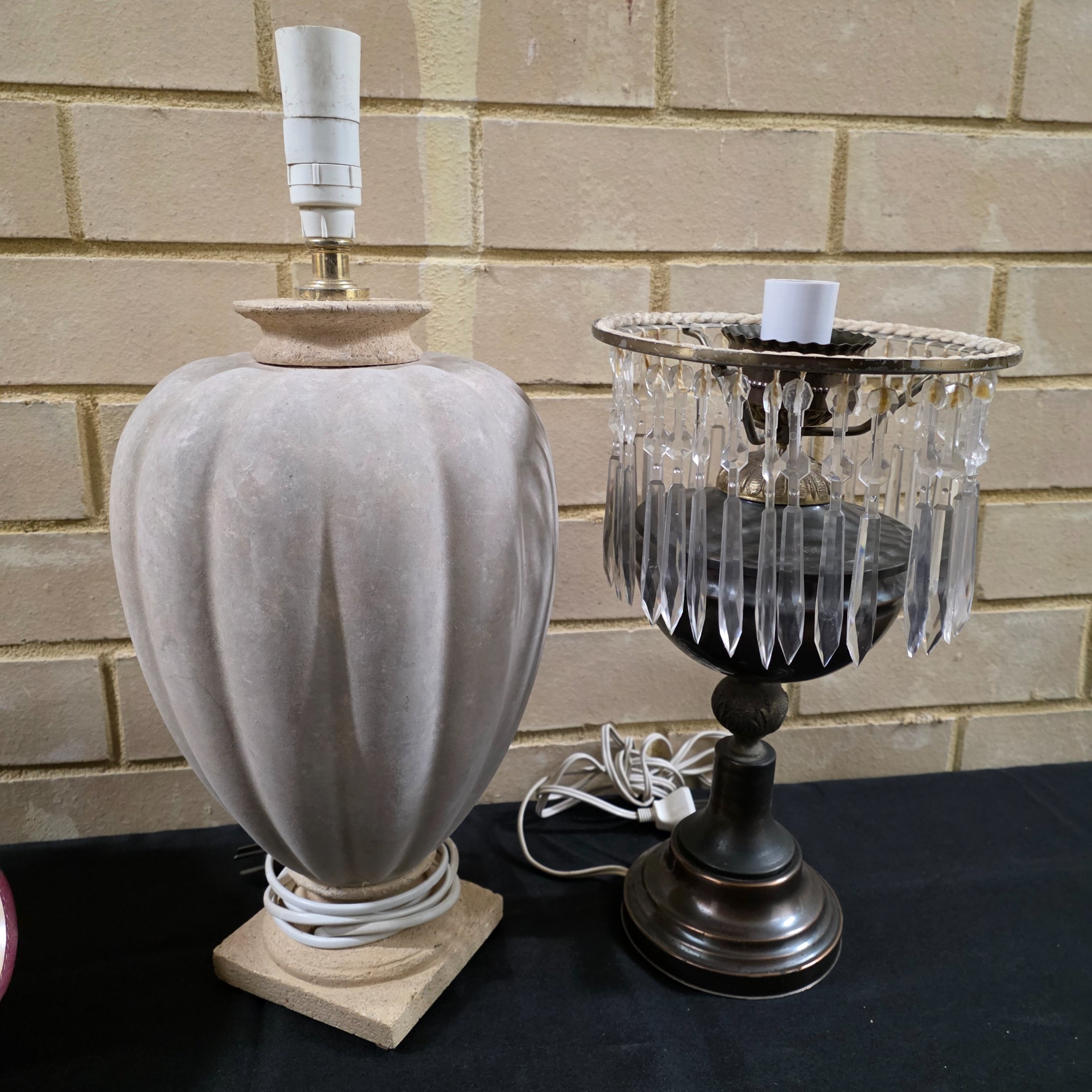 A lot consisting of two vintage lamp bases – one cream-grey fluted ceramic and one bronze-toned with hanging clear crystals – alongside a white pleated fabric lampshade and an intricately carved wooden lampshade. - View 8
