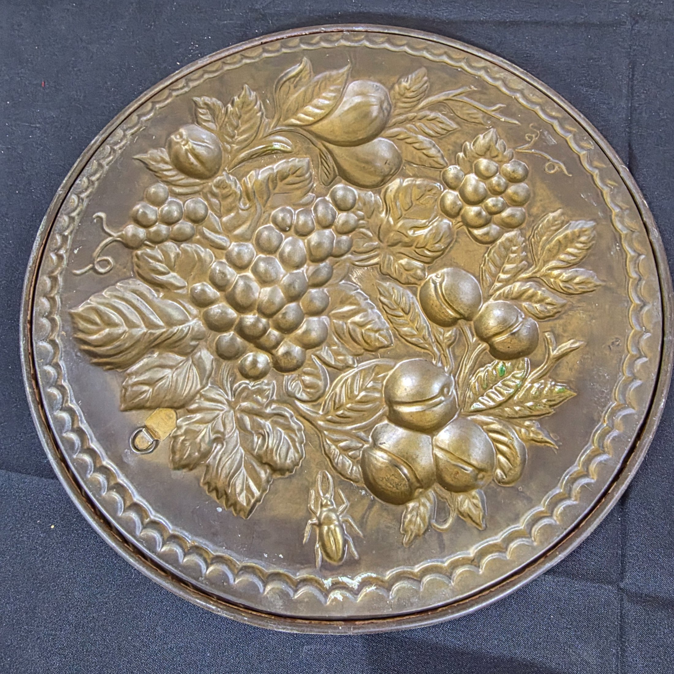 A set of three vintage decorative wall plaques, featuring embossed fruit designs in brass and copper-toned metal. - View 6