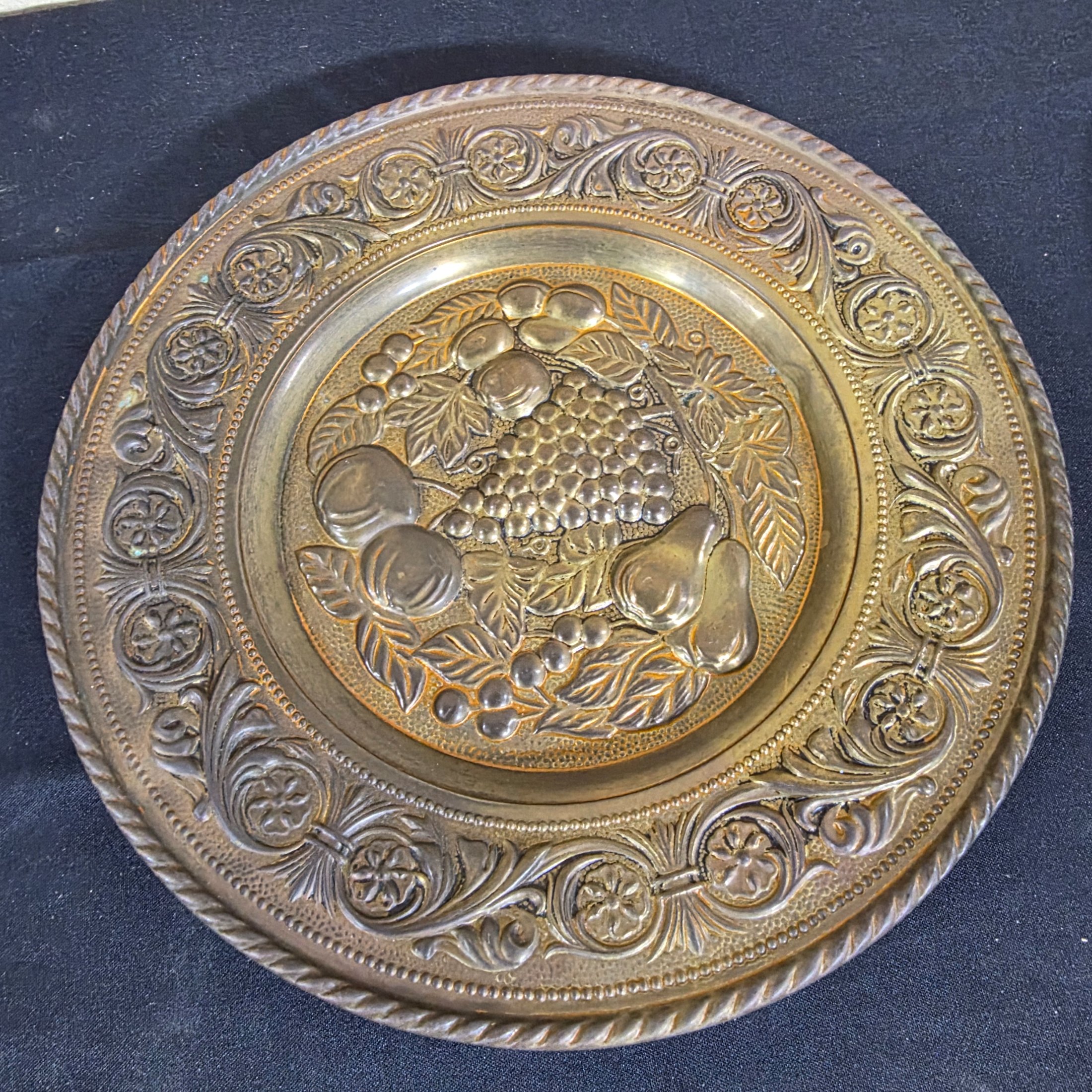 A set of three vintage decorative wall plaques, featuring embossed fruit designs in brass and copper-toned metal. - View 8