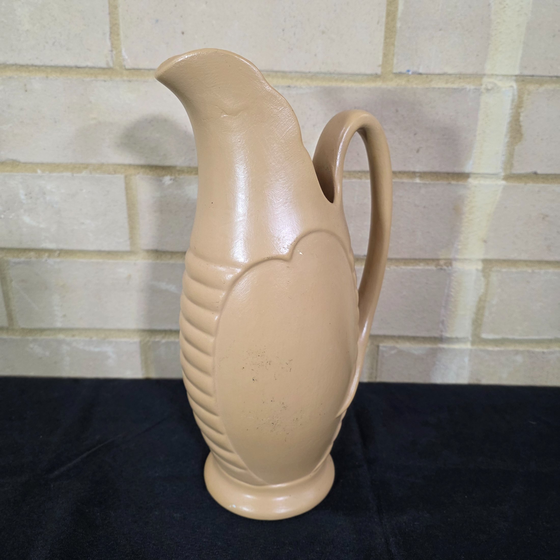 A vintage English ceramic pitcher jug, likely mid-20th century, crafted in a light tan/beige glaze with a distinctive ribbed body design.