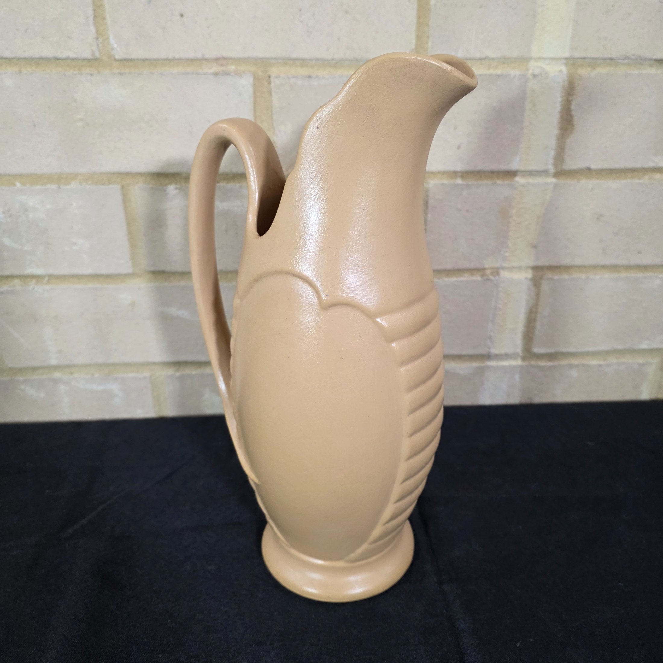 A vintage English ceramic pitcher jug, likely mid-20th century, crafted in a light tan/beige glaze with a distinctive ribbed body design. - View 2