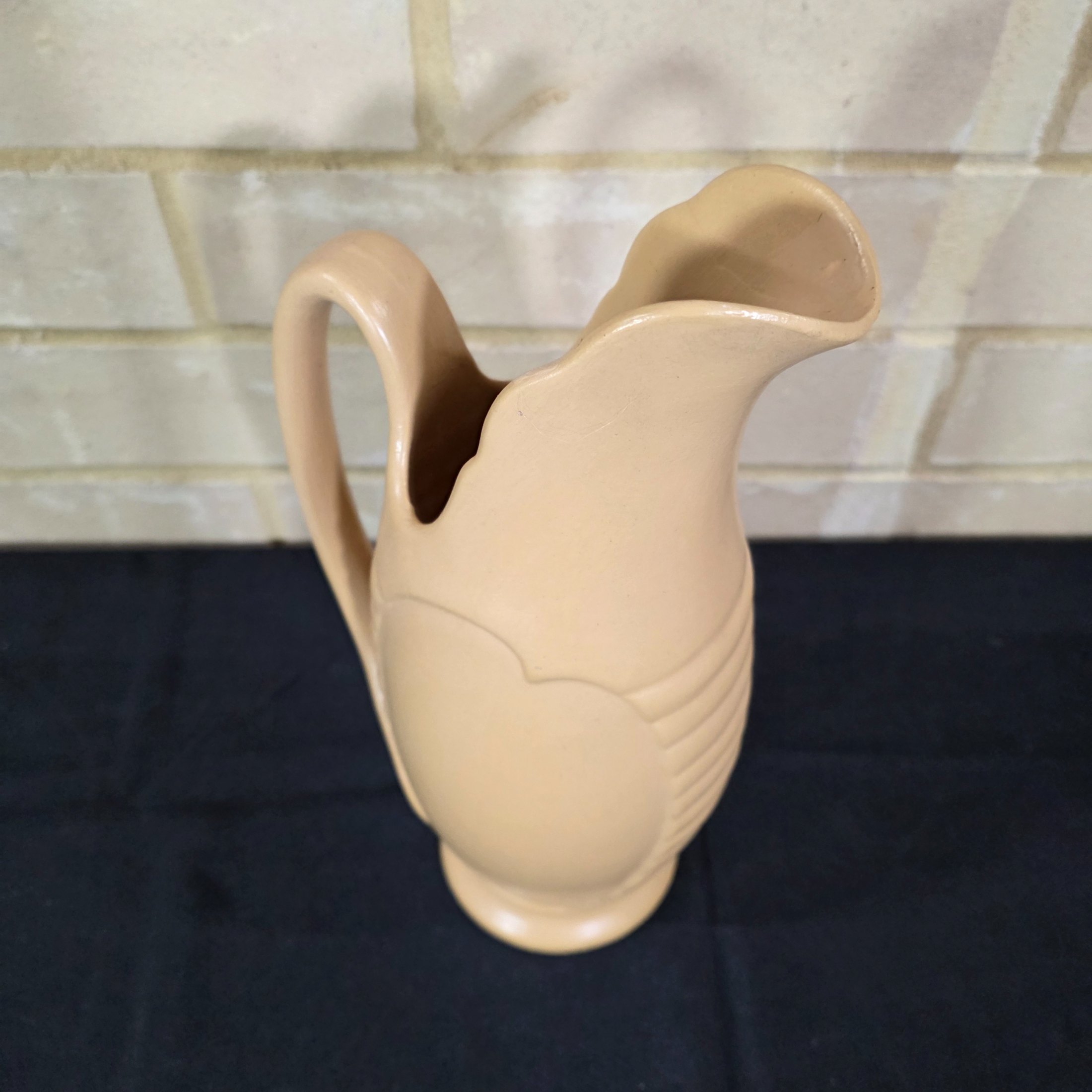 A vintage English ceramic pitcher jug, likely mid-20th century, crafted in a light tan/beige glaze with a distinctive ribbed body design. - View 3