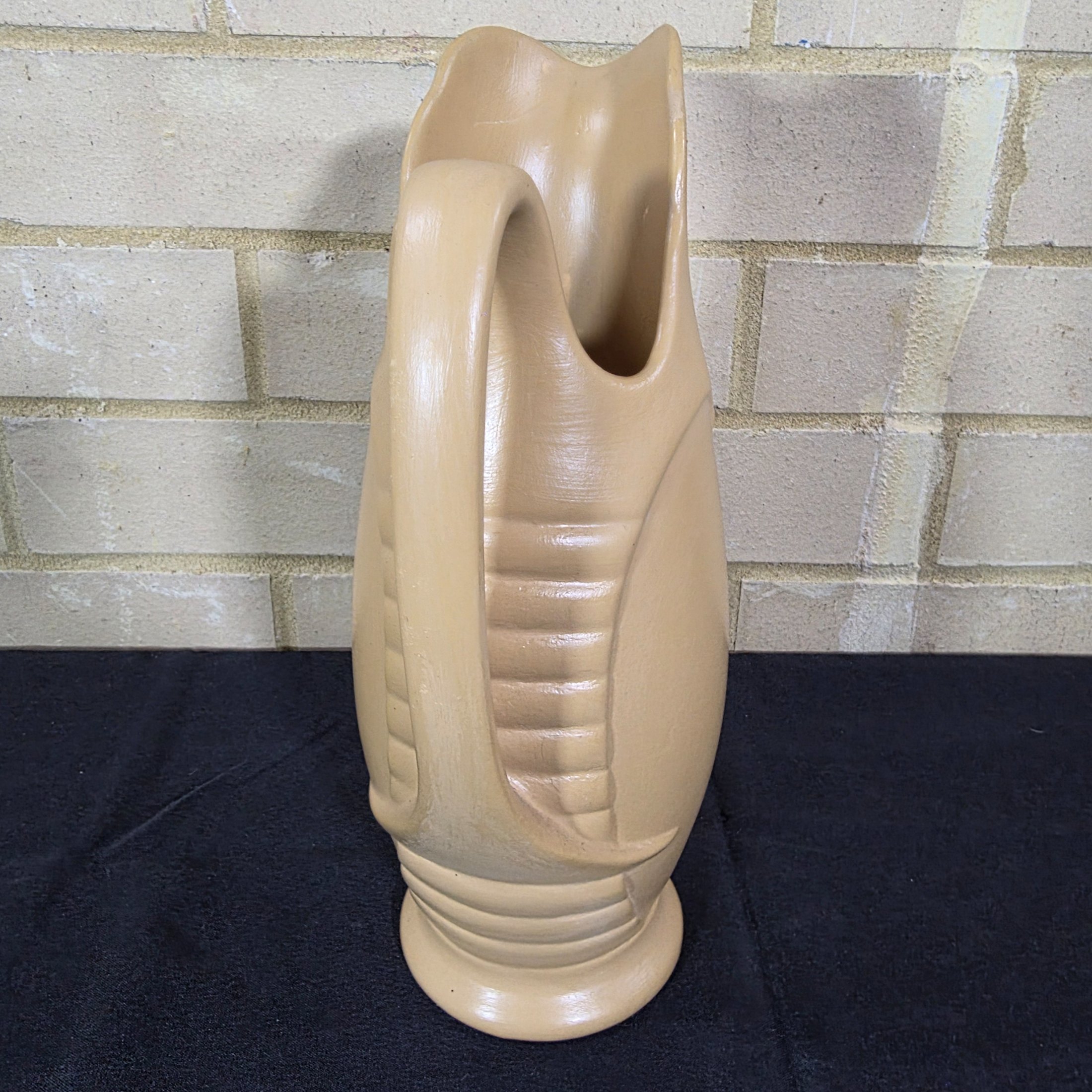 A vintage English ceramic pitcher jug, likely mid-20th century, crafted in a light tan/beige glaze with a distinctive ribbed body design. - View 4