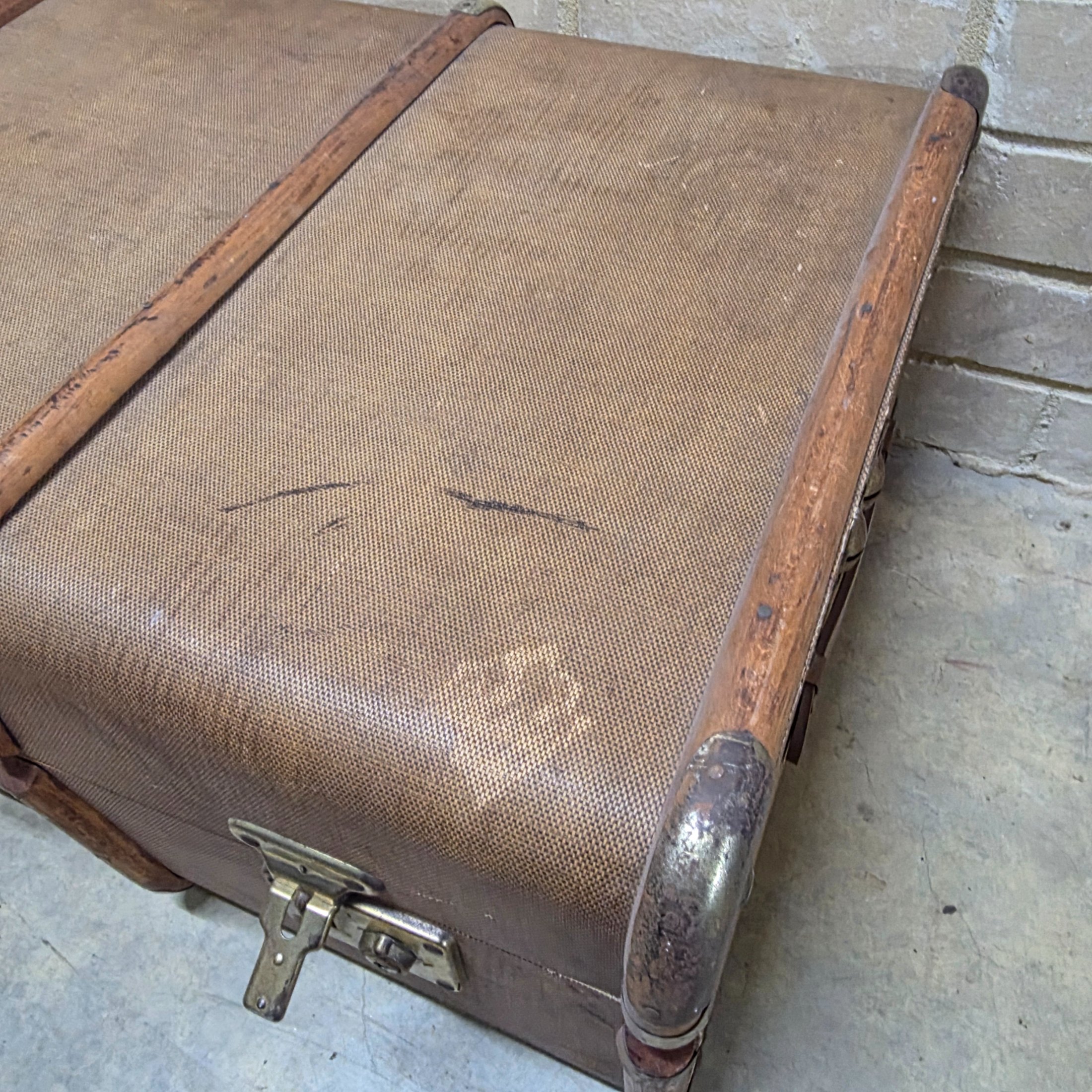 A classic vintage travel trunk from the early 20th century, made from woven fabric over a wooden frame with reinforcing wooden slats and metal hardware. - View 4
