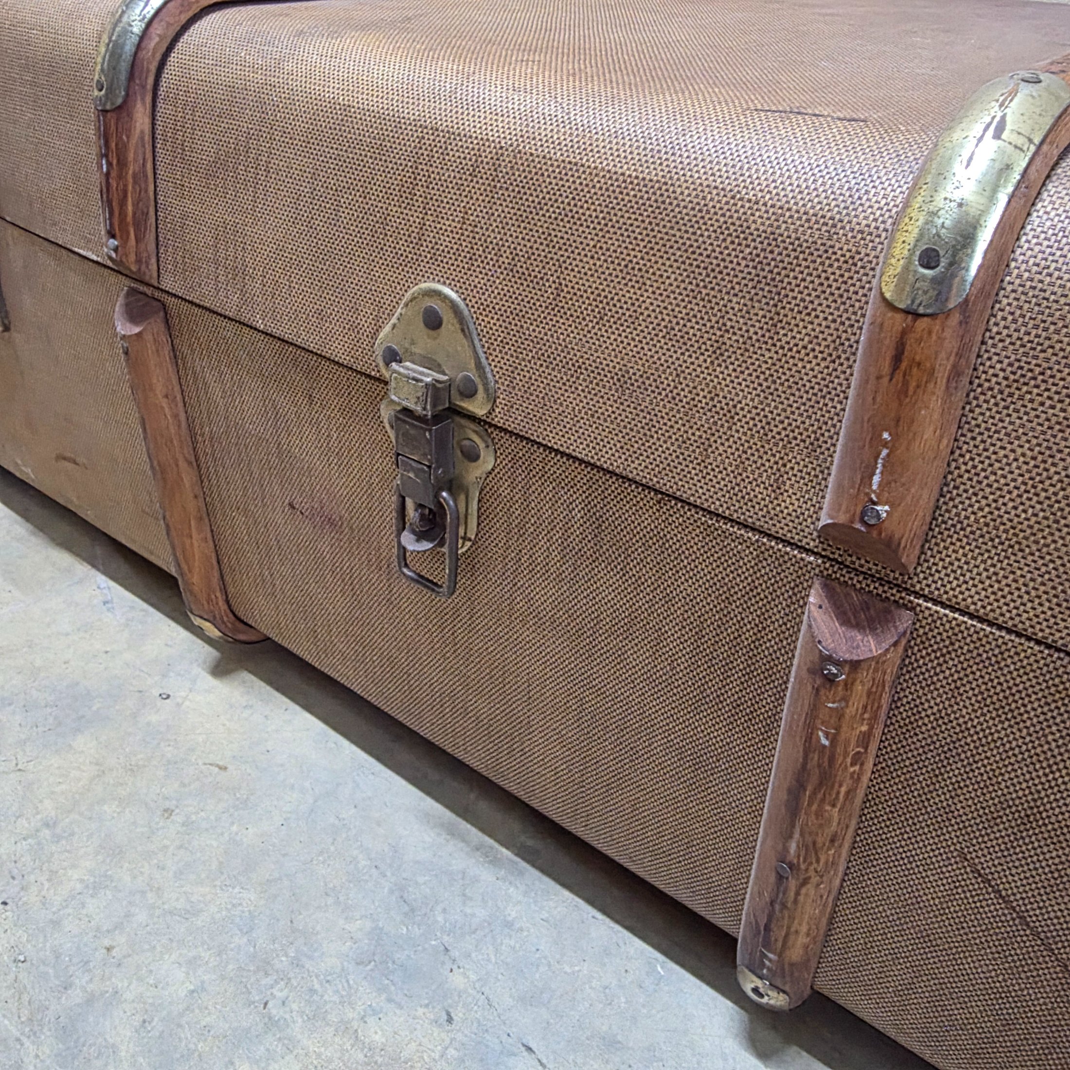 A classic vintage travel trunk from the early 20th century, made from woven fabric over a wooden frame with reinforcing wooden slats and metal hardware. - View 5