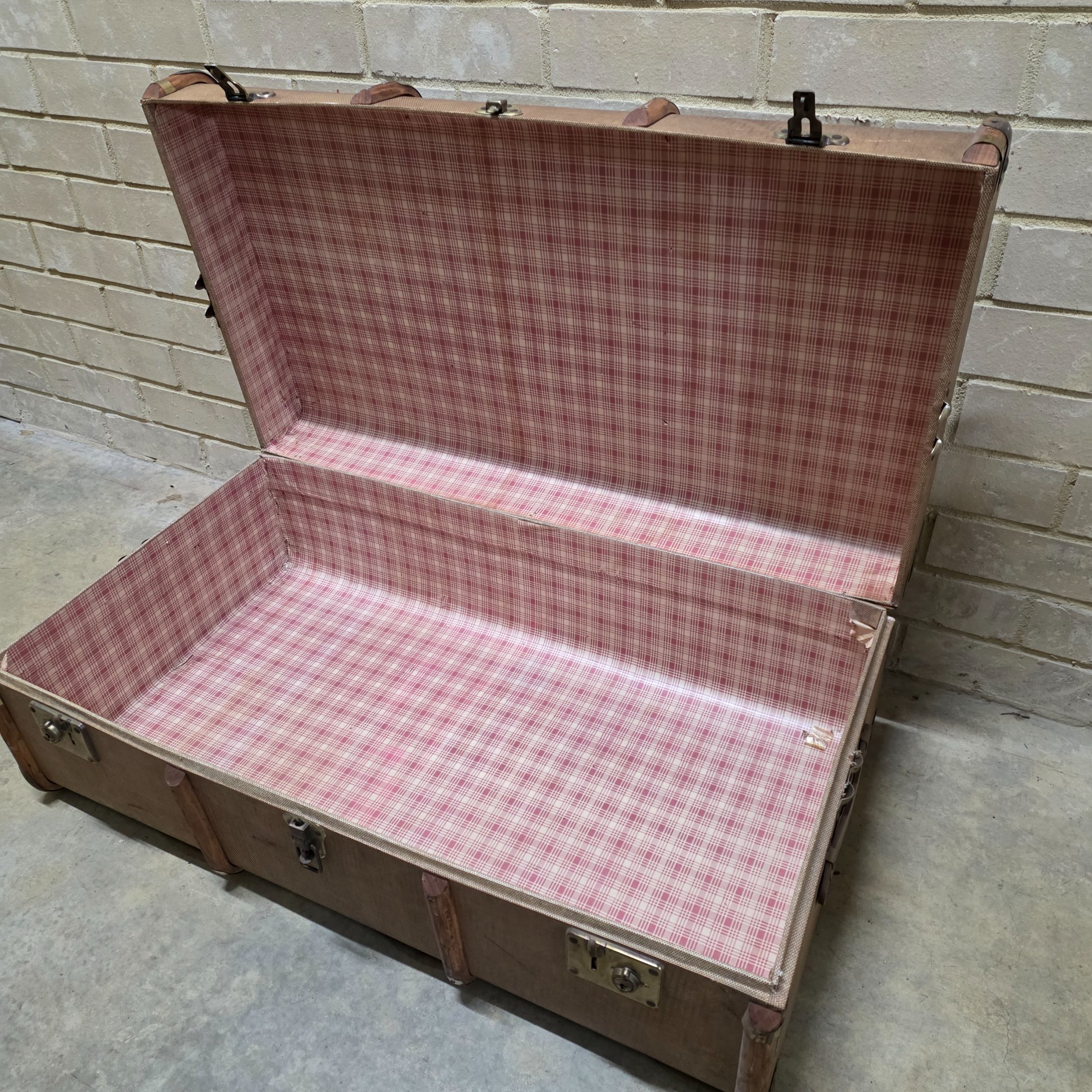 A classic vintage travel trunk from the early 20th century, made from woven fabric over a wooden frame with reinforcing wooden slats and metal hardware. - View 6