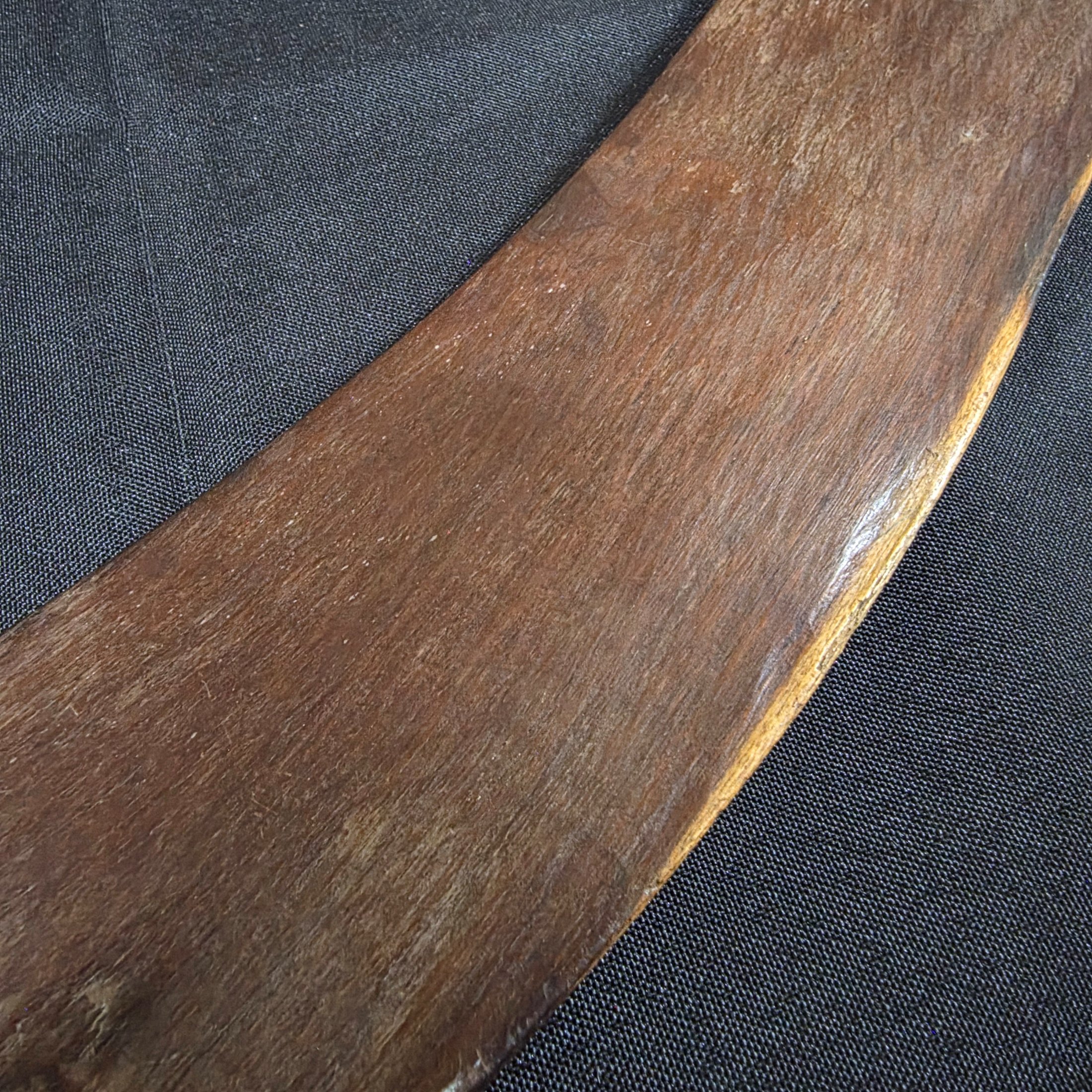 A vintage hand-carved wooden boomerang with a natural dark brown finish, approximately 62cm in length. - View 4