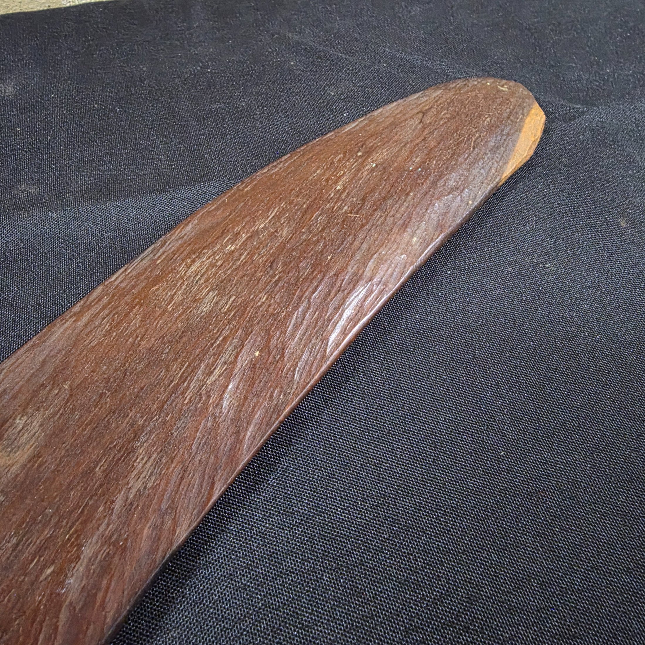 A vintage hand-carved wooden boomerang with a natural dark brown finish, approximately 62cm in length. - View 5