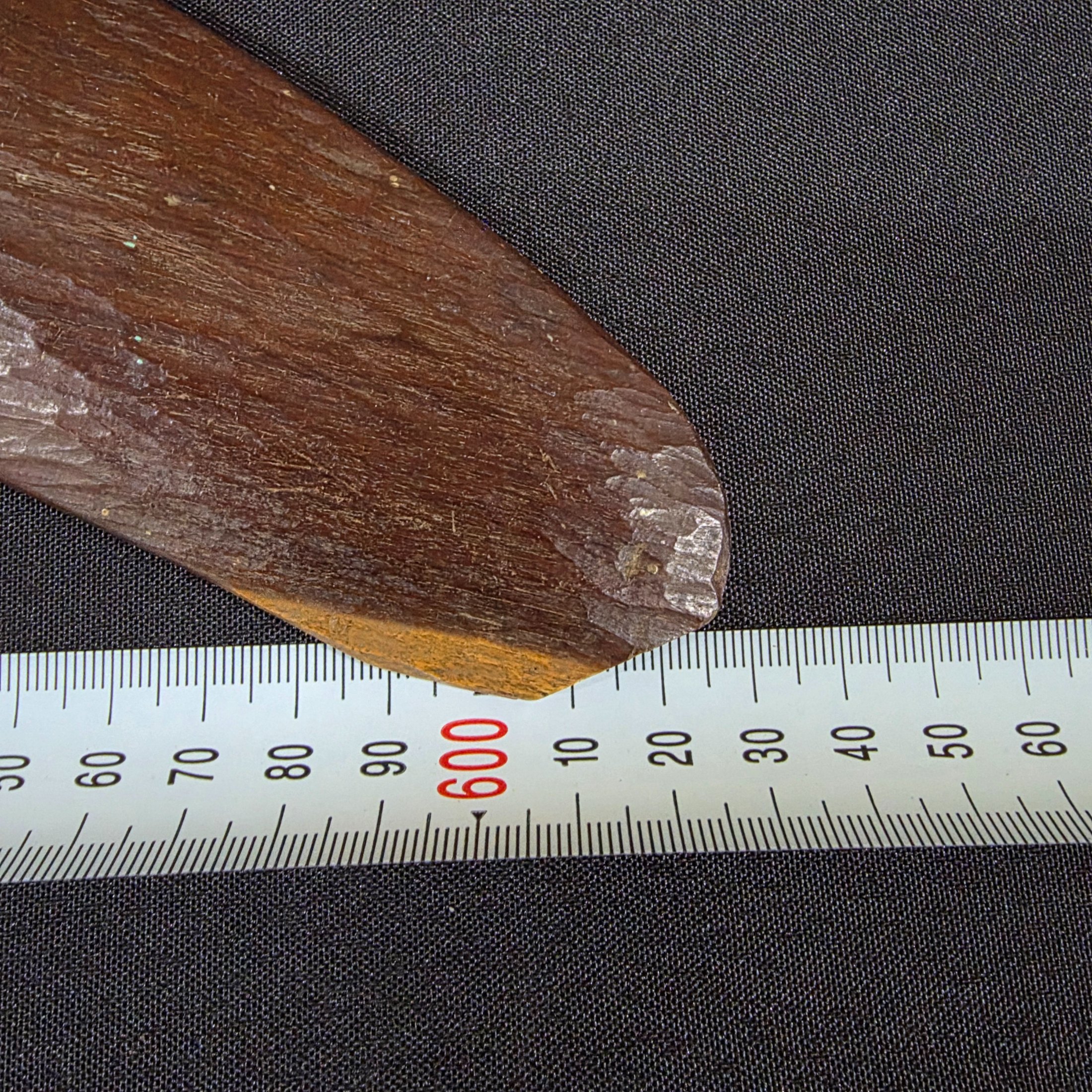 A vintage hand-carved wooden boomerang with a natural dark brown finish, approximately 62cm in length. - View 7