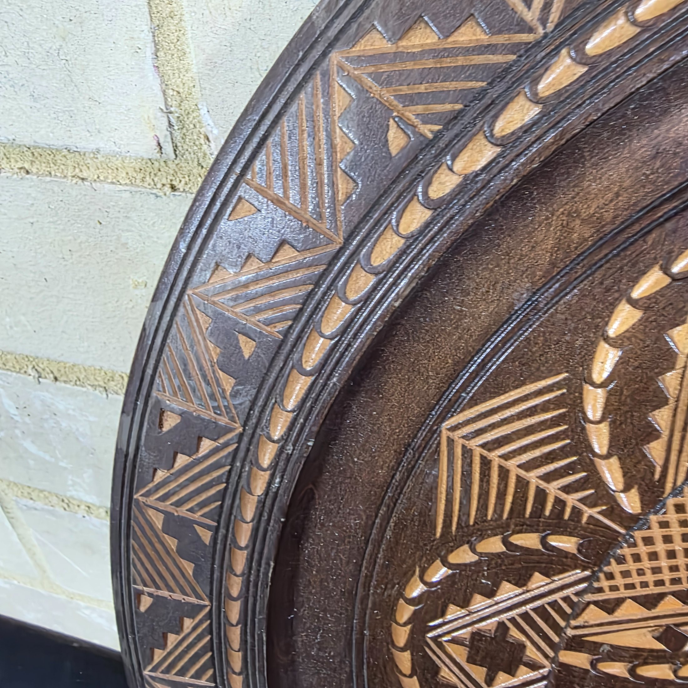 A vintage hand-carved wooden decorative plate, featuring intricate geometric and radial chip-carved patterns revealing lighter wood beneath a dark stain, likely mid-20th century. - View 3