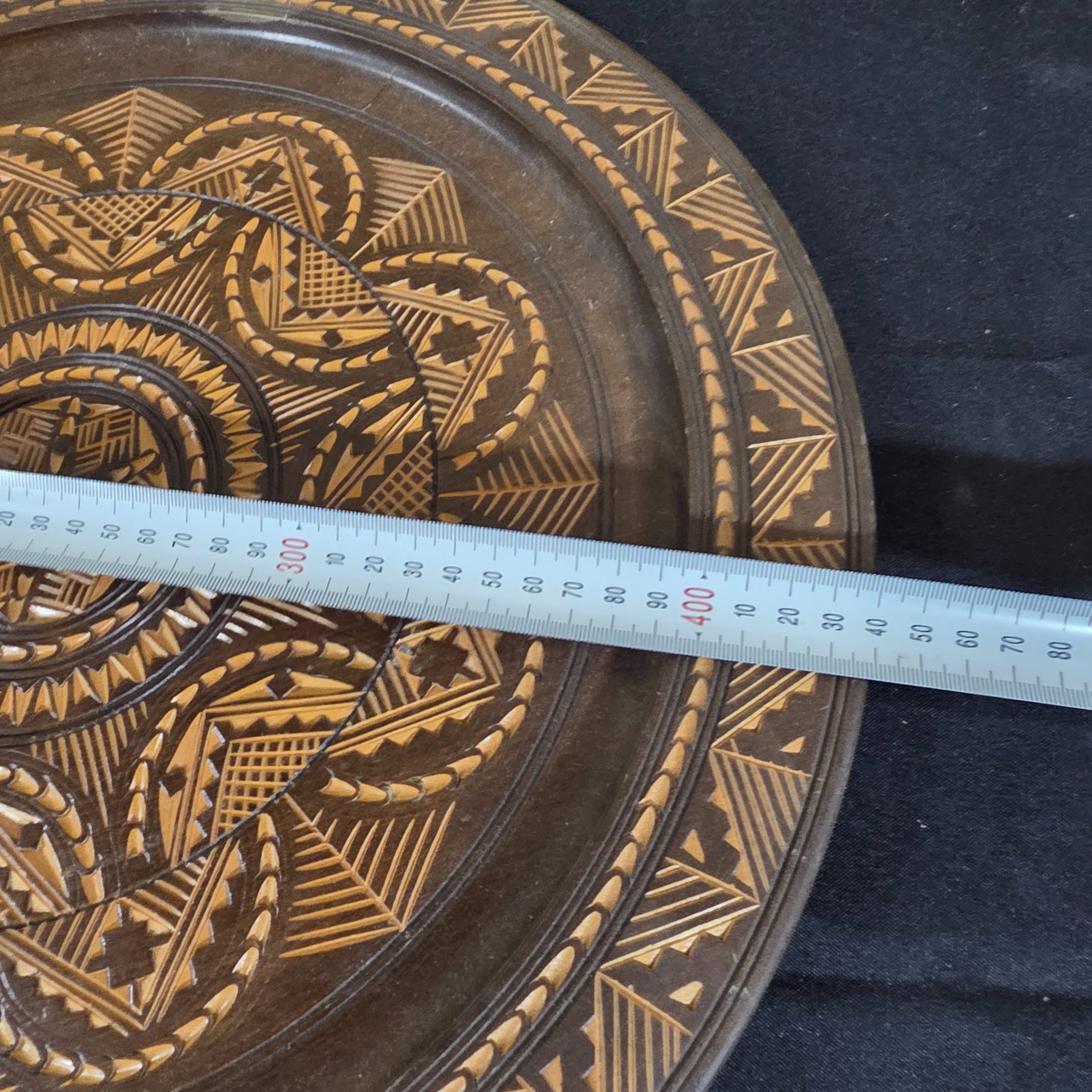 A vintage hand-carved wooden decorative plate, featuring intricate geometric and radial chip-carved patterns revealing lighter wood beneath a dark stain, likely mid-20th century. - View 5