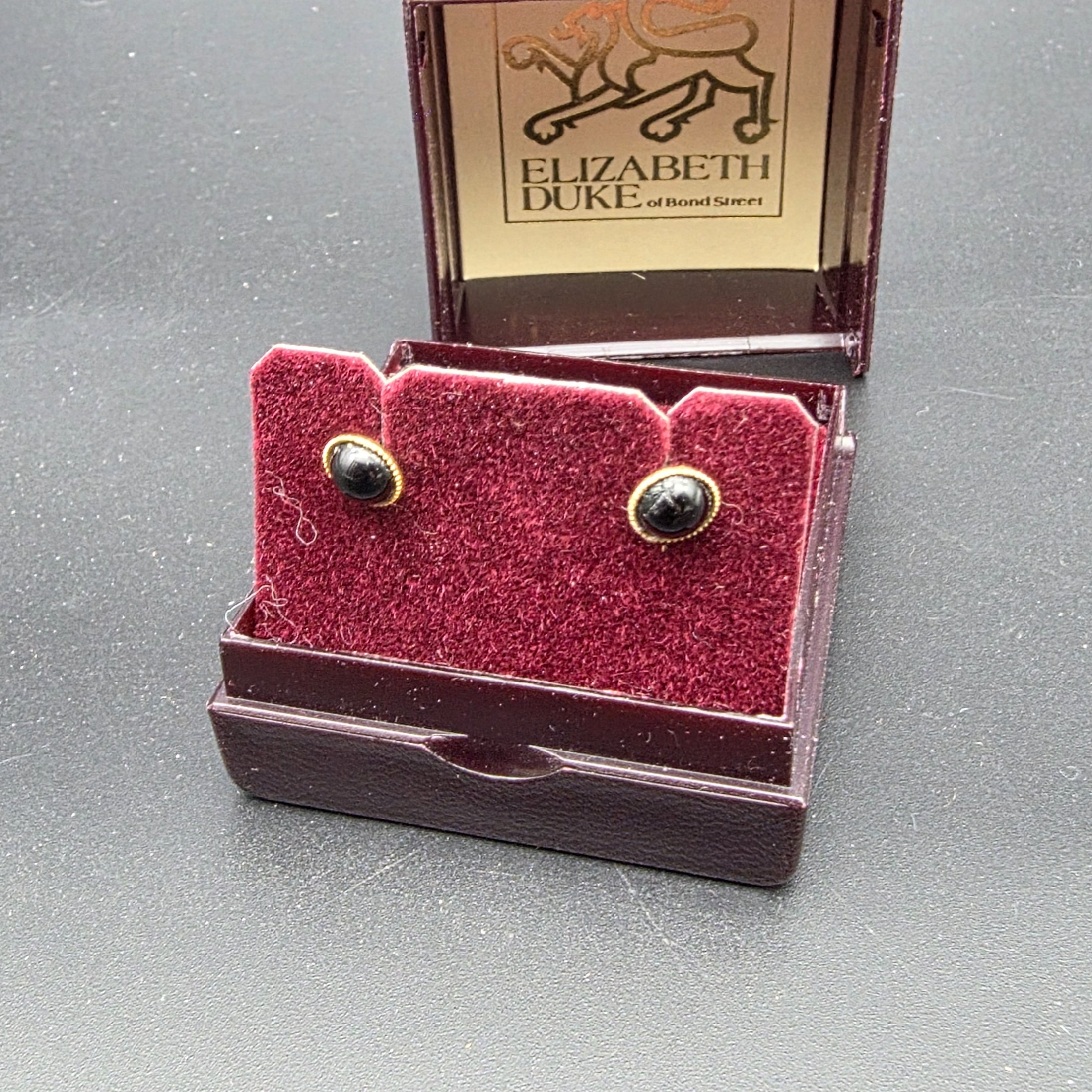 A vintage Elizabeth Duke of Bond Street jewellery set, crafted from 9ct gold and featuring elegant black cabochon stones, presented in its original branded box. This classic ensemble comprises a delicate chain necklace and matching stud earrings. - View 2