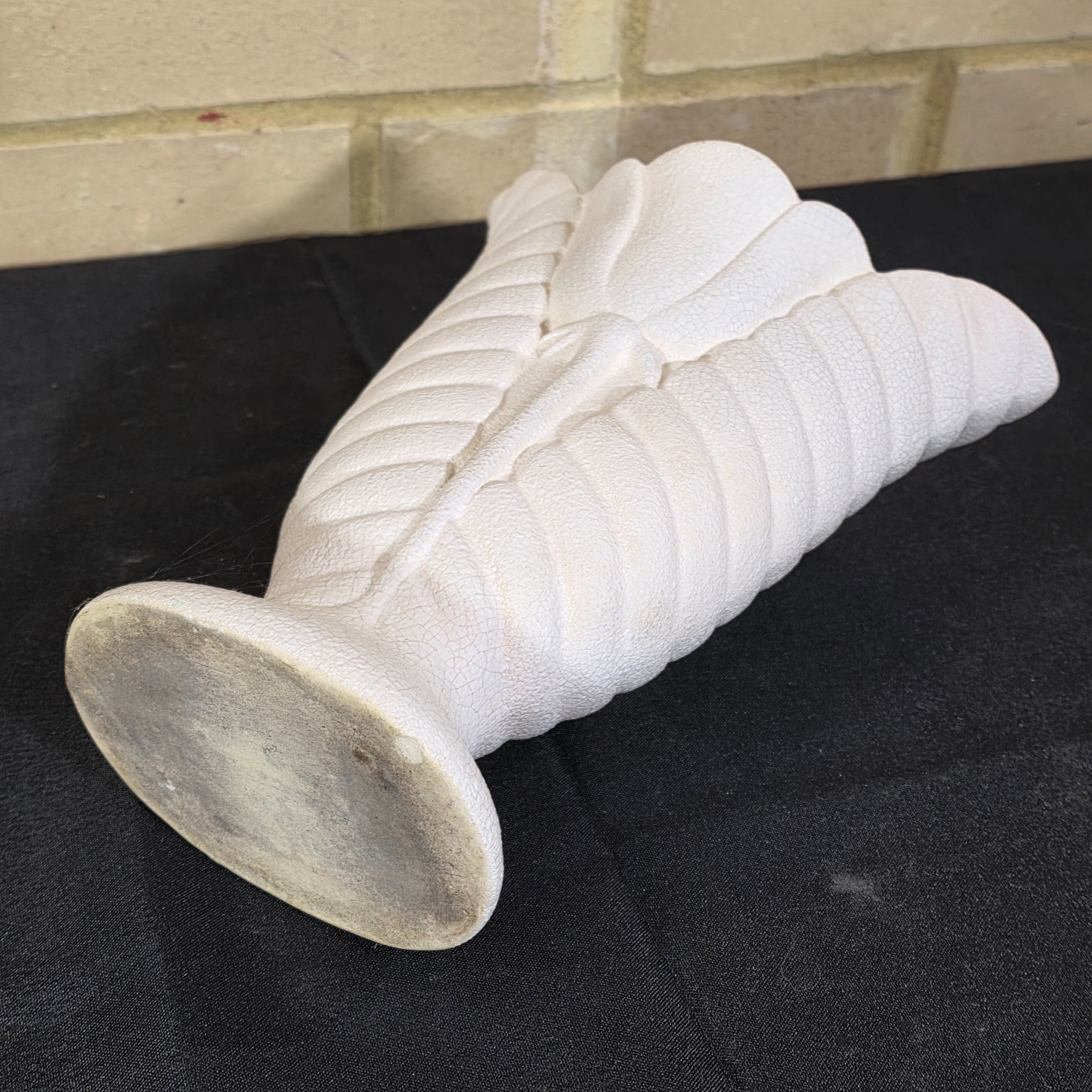 A striking white ceramic vase, likely from the mid-20th century, distinguished by its textured, fluted body reminiscent of a shell or stylized leaf. The piece features a prominent crackle glaze on both its off-white exterior and pale yellow interior. - View 4