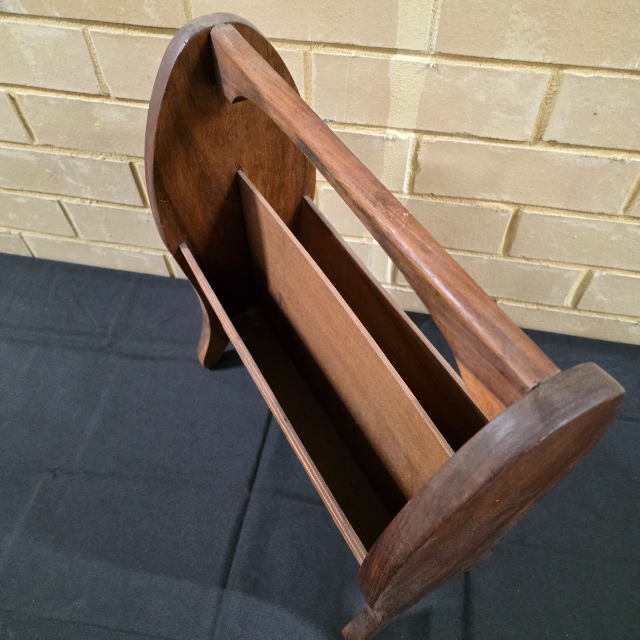 A classic vintage mid-century wooden magazine rack, featuring a curved handle and two functional compartments for storage. This piece showcases the simple, elegant design characteristic of its era, crafted from solid wood with a warm, natural finish. - View 2