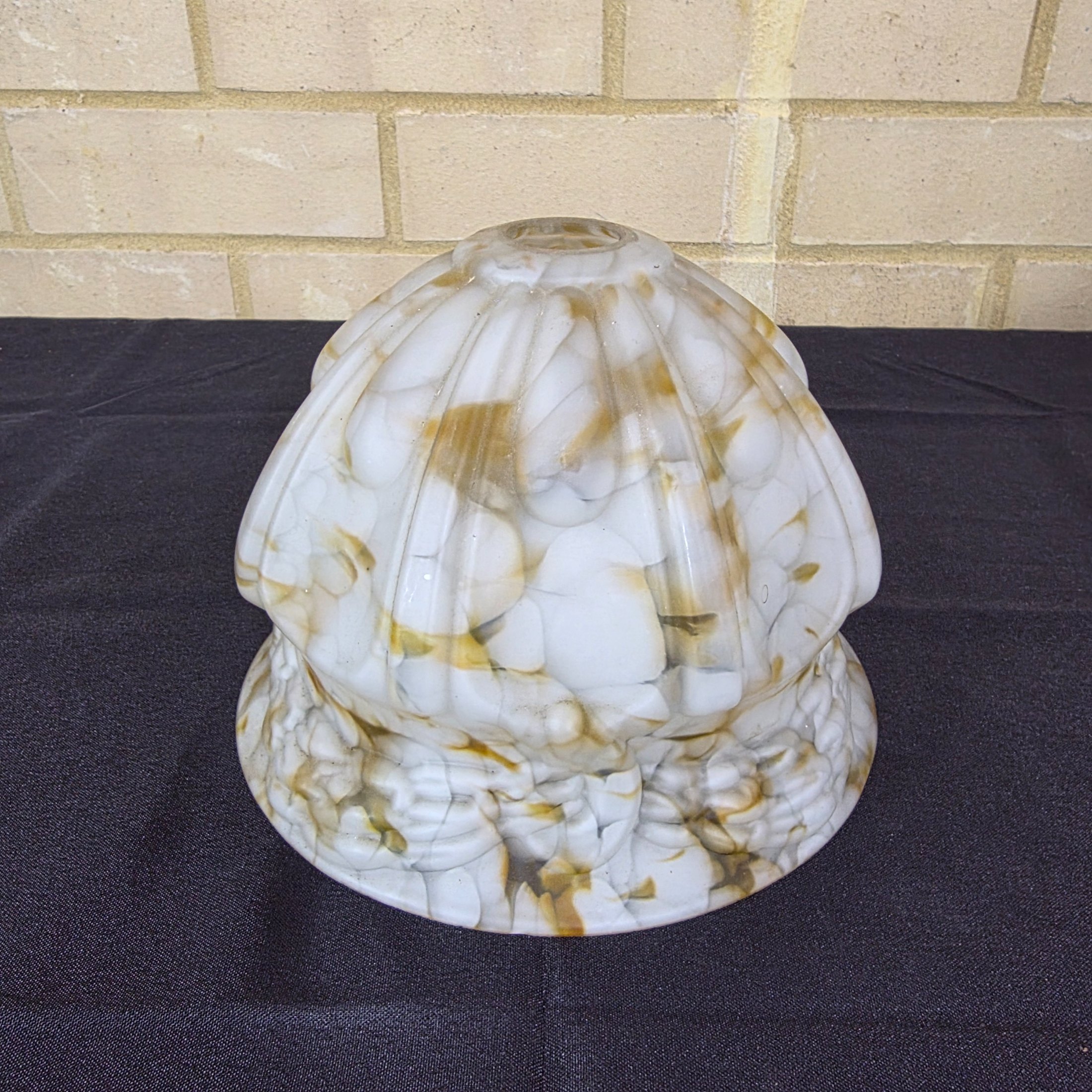 A vintage decorative glass light shade, featuring a marbled white and amber slag glass pattern with a fluted, ruffled design, circa mid-20th century.