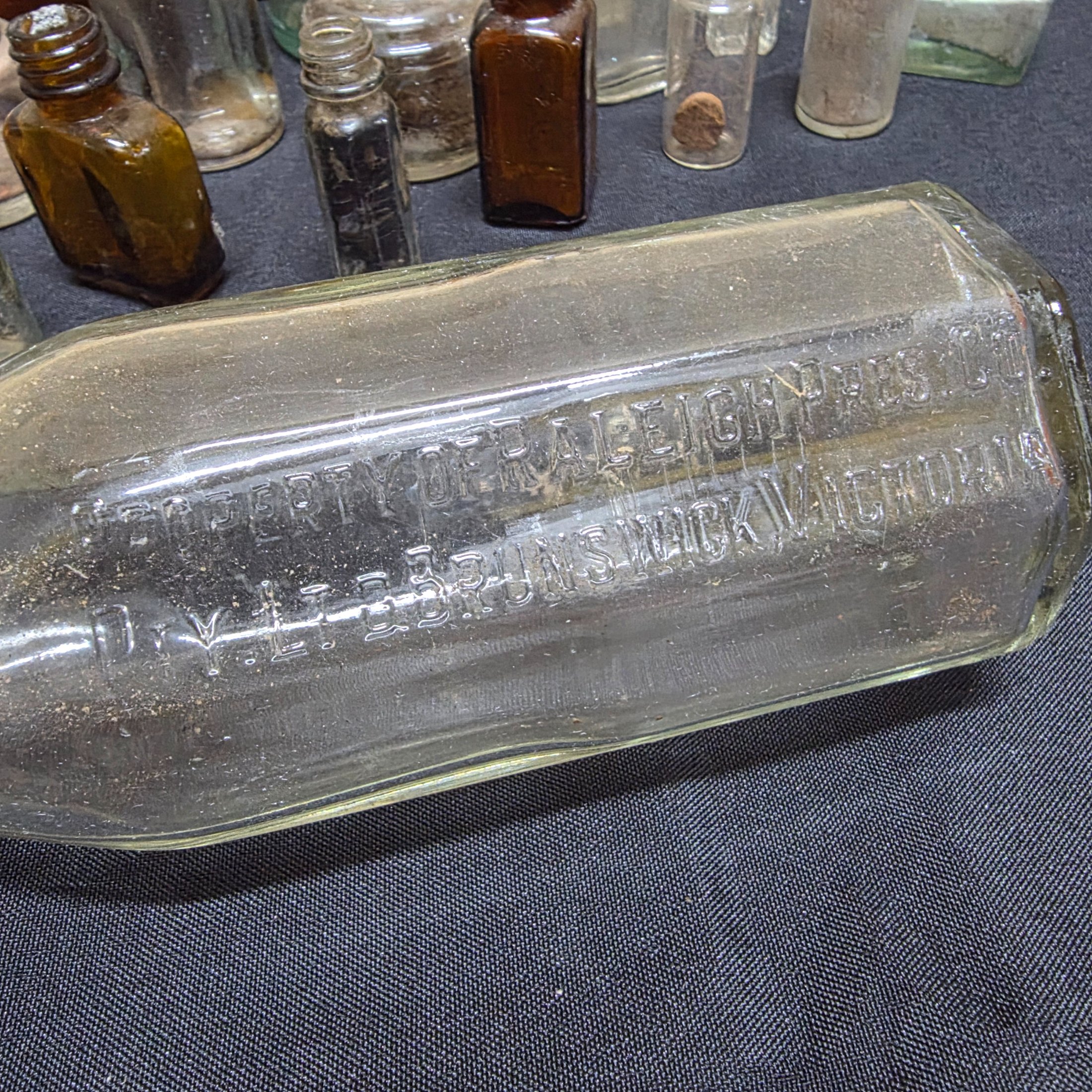 A diverse collection of antique and vintage glass and ceramic bottles and jars, dating from the late 19th to mid-20th century, showcasing various styles and materials. - View 3