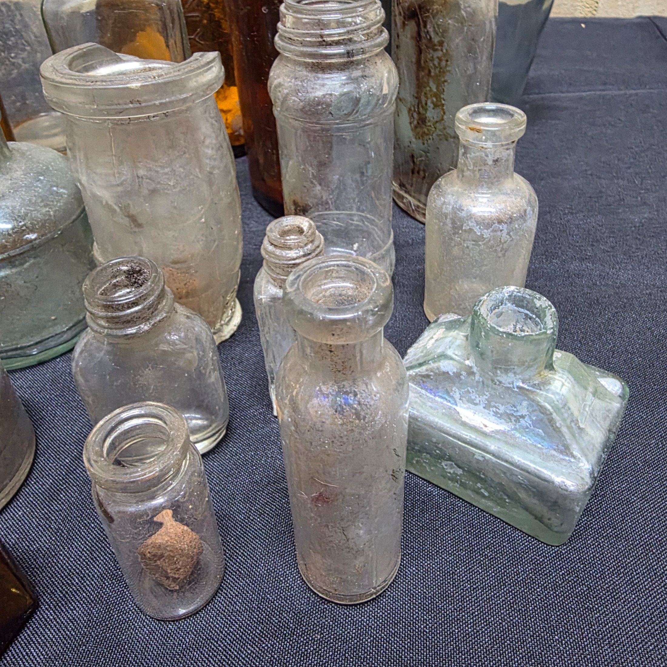 A diverse collection of antique and vintage glass and ceramic bottles and jars, dating from the late 19th to mid-20th century, showcasing various styles and materials. - View 4