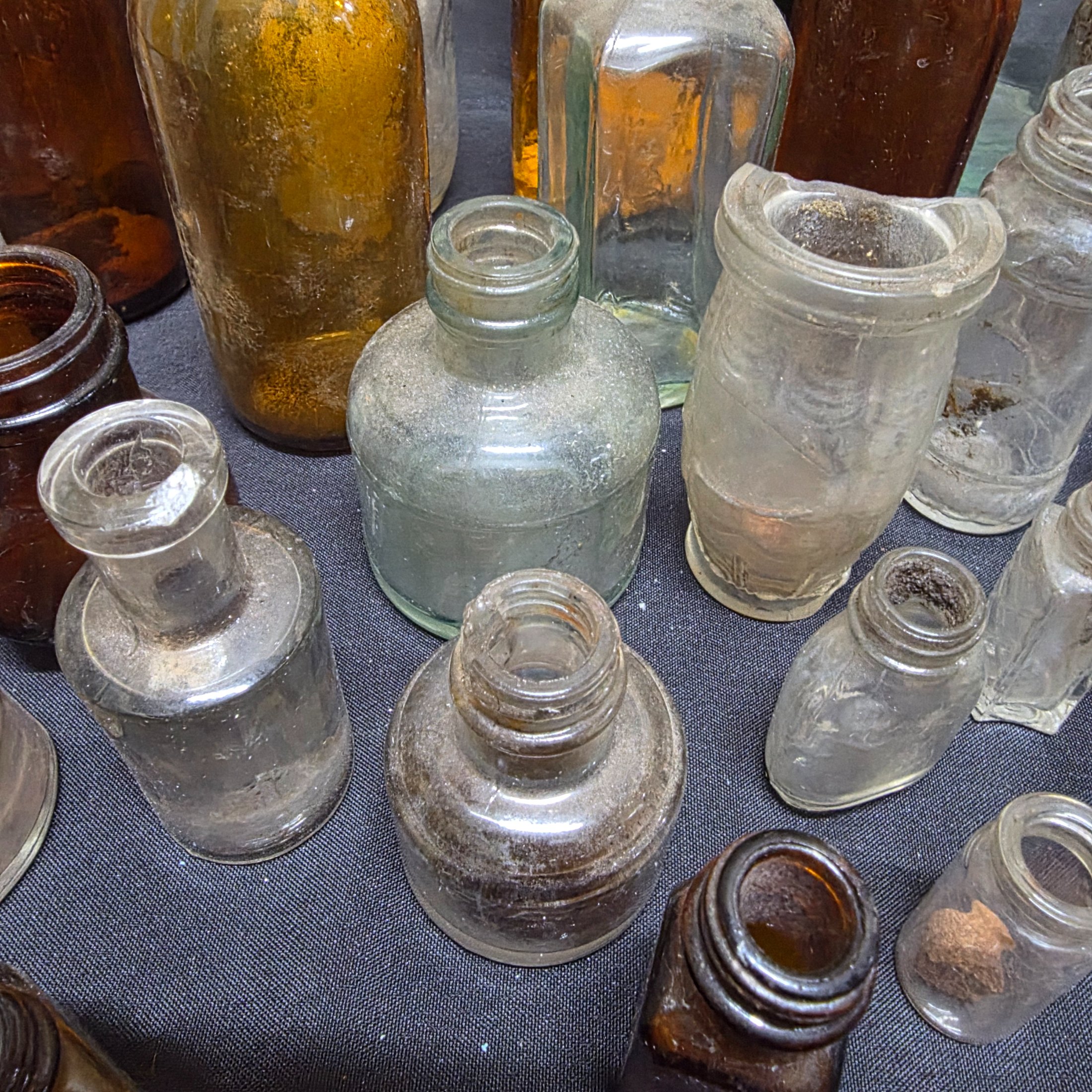 A diverse collection of antique and vintage glass and ceramic bottles and jars, dating from the late 19th to mid-20th century, showcasing various styles and materials. - View 5