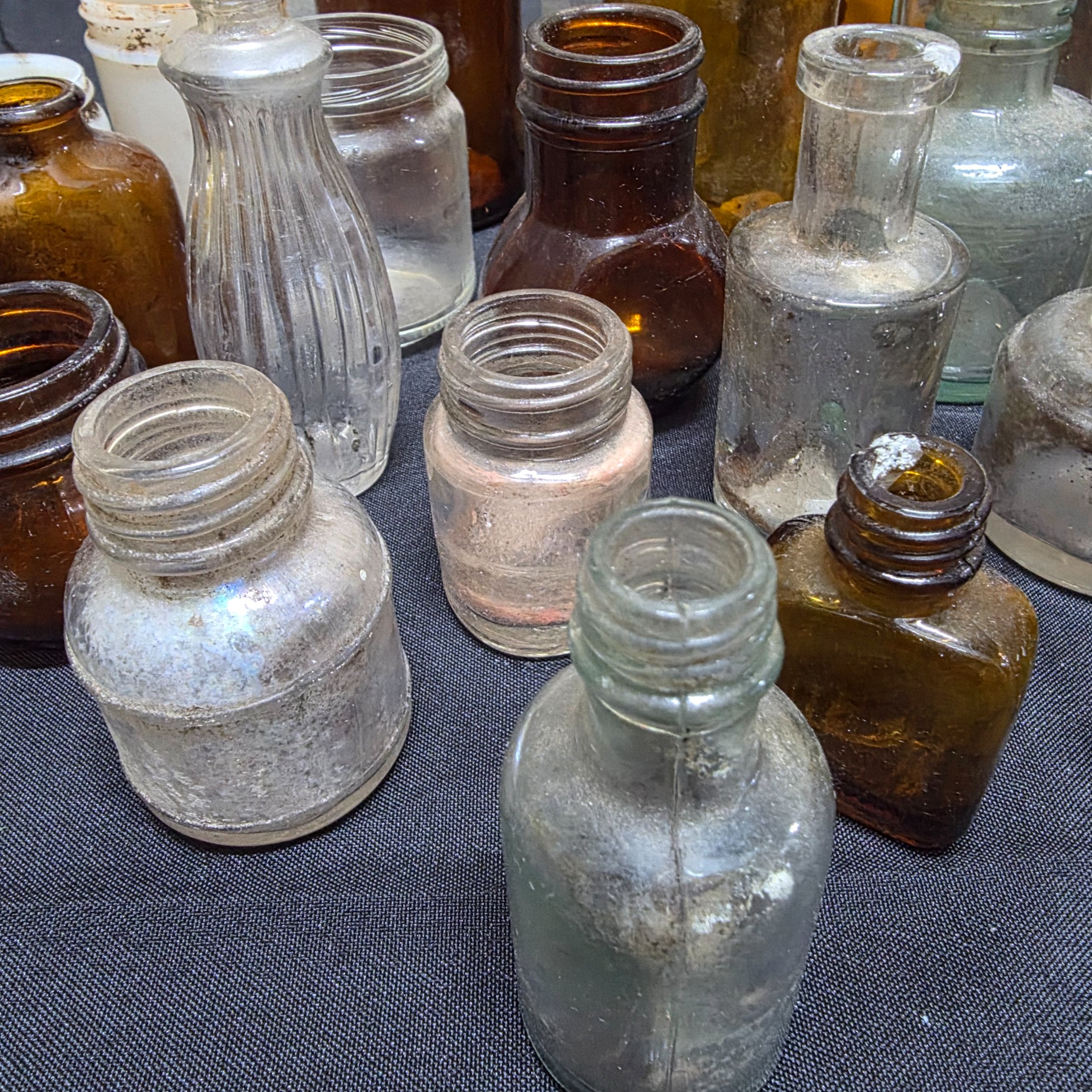A diverse collection of antique and vintage glass and ceramic bottles and jars, dating from the late 19th to mid-20th century, showcasing various styles and materials. - View 6