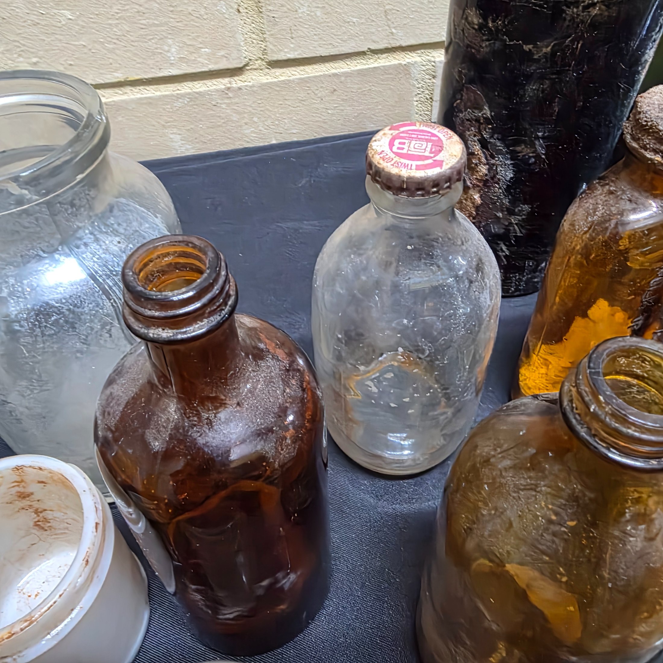 A diverse collection of antique and vintage glass and ceramic bottles and jars, dating from the late 19th to mid-20th century, showcasing various styles and materials. - View 8