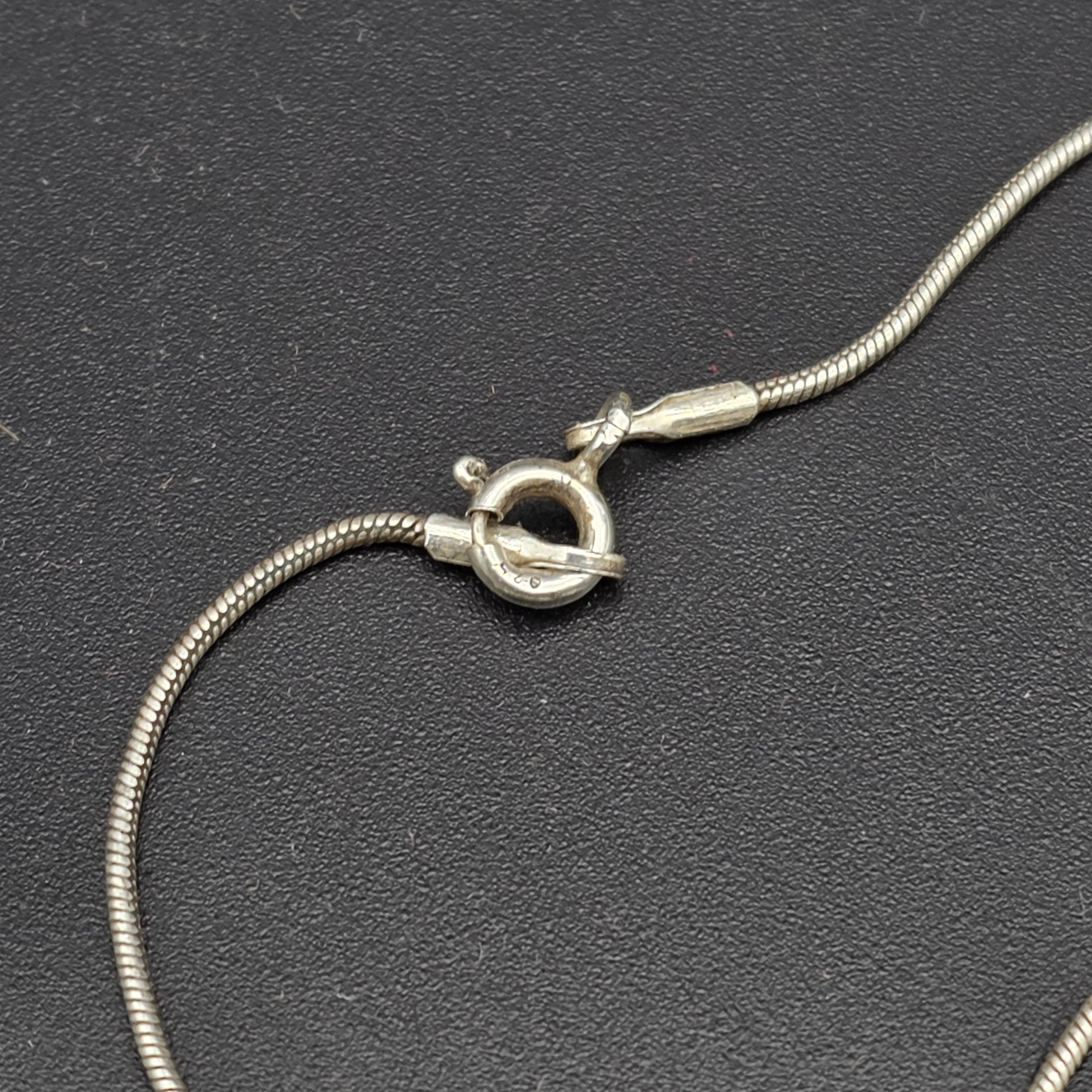 A matching Paul Kennedy sterling silver and baroque freshwater pearl necklace and earring set. This contemporary jewellery suite features a snake chain necklace with a single irregular pearl pendant and a pair of coordinating hook earrings, each set with a baroque pearl. - View 6