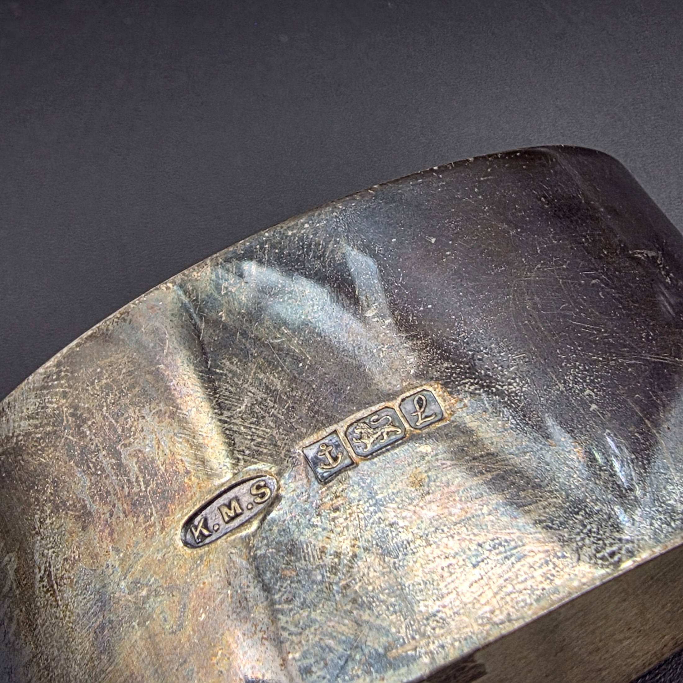 A collection of four vintage silver-toned items, including a sterling silver napkin ring, a second napkin ring, a ribbed cup, and a lidded box, dating from the early to mid-20th century. - View 2