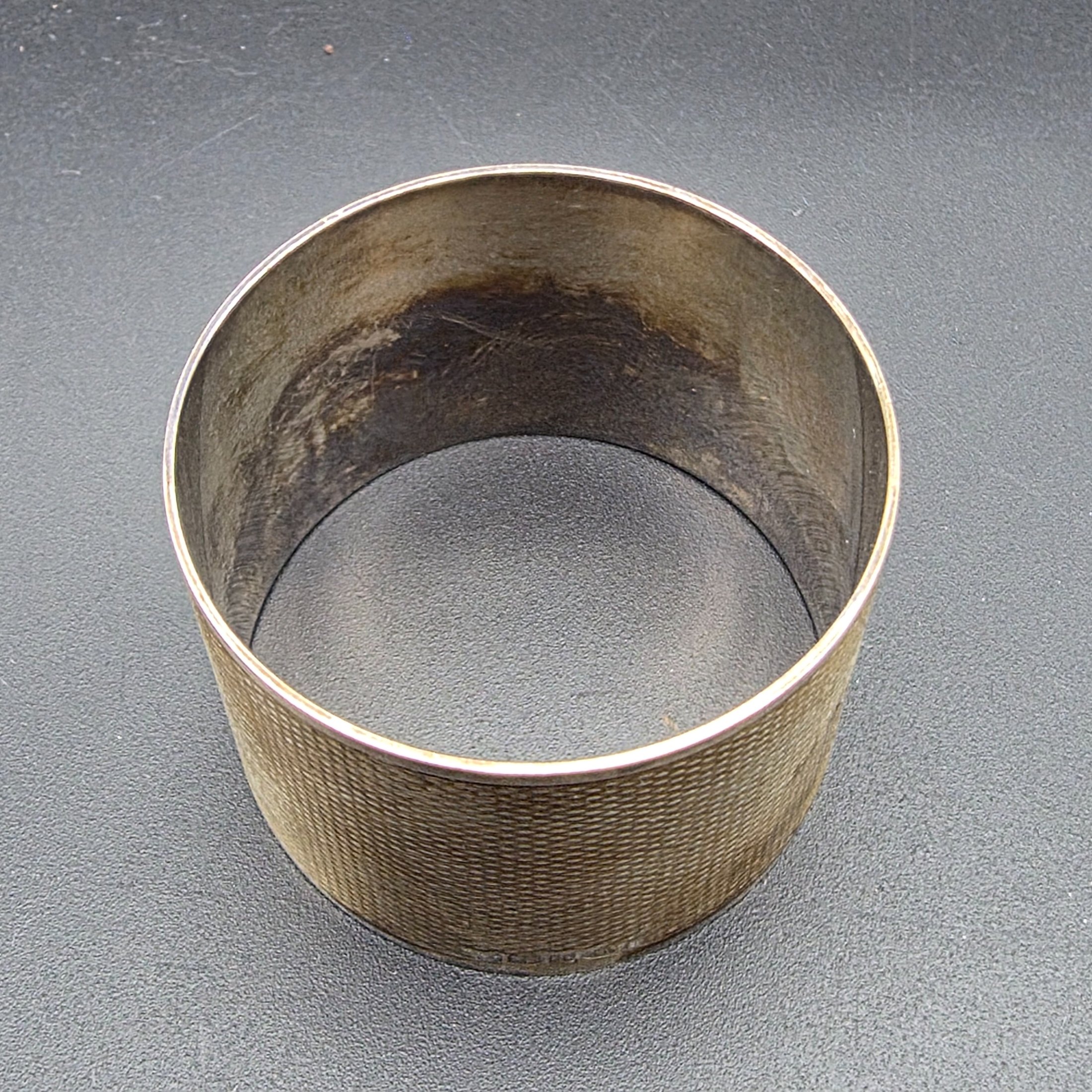 A collection of four vintage silver-toned items, including a sterling silver napkin ring, a second napkin ring, a ribbed cup, and a lidded box, dating from the early to mid-20th century. - View 4