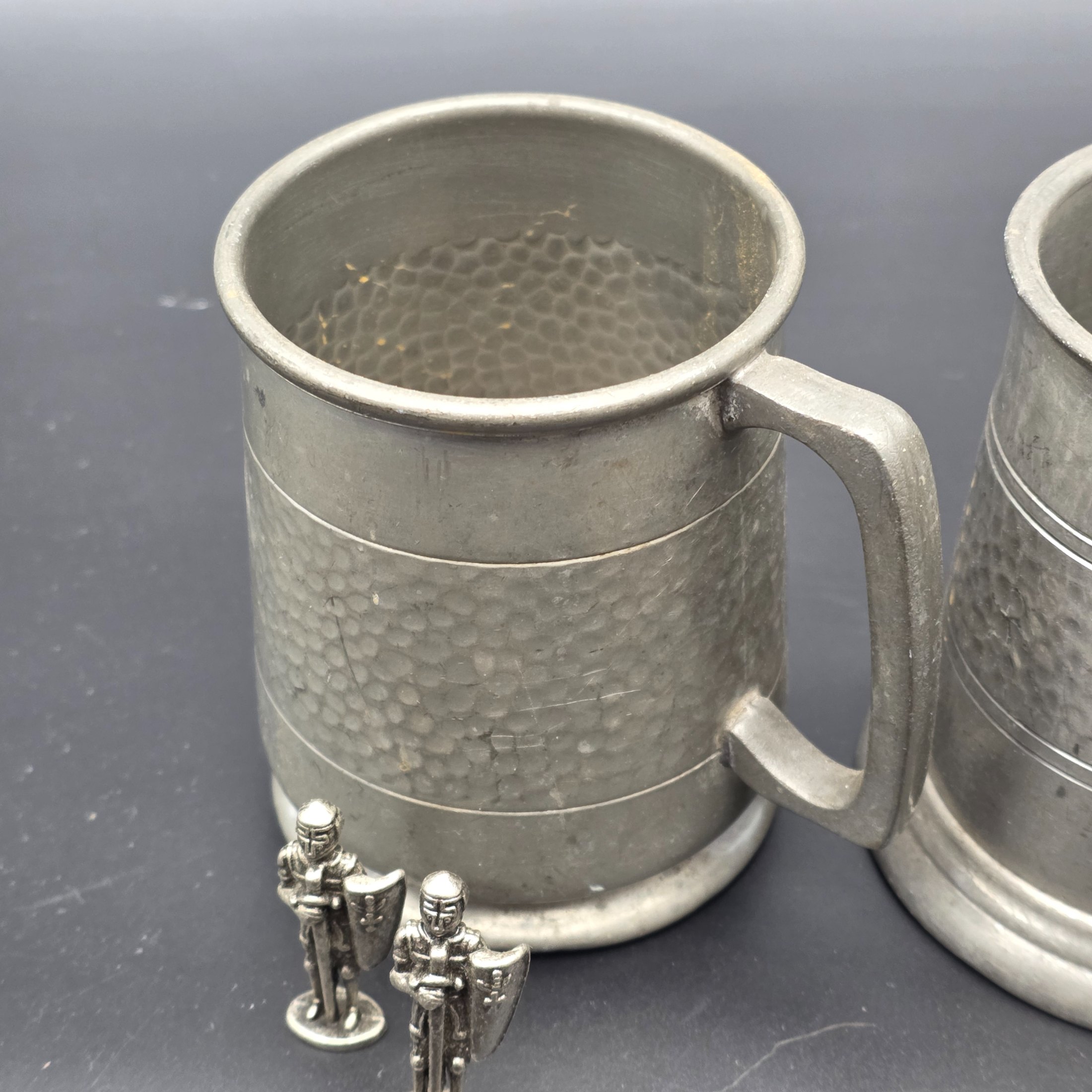 A collection featuring three vintage pewter tankards and two small pewter knight figurines, showcasing different manufacturing origins and finishes from the mid to late 20th century. - View 3